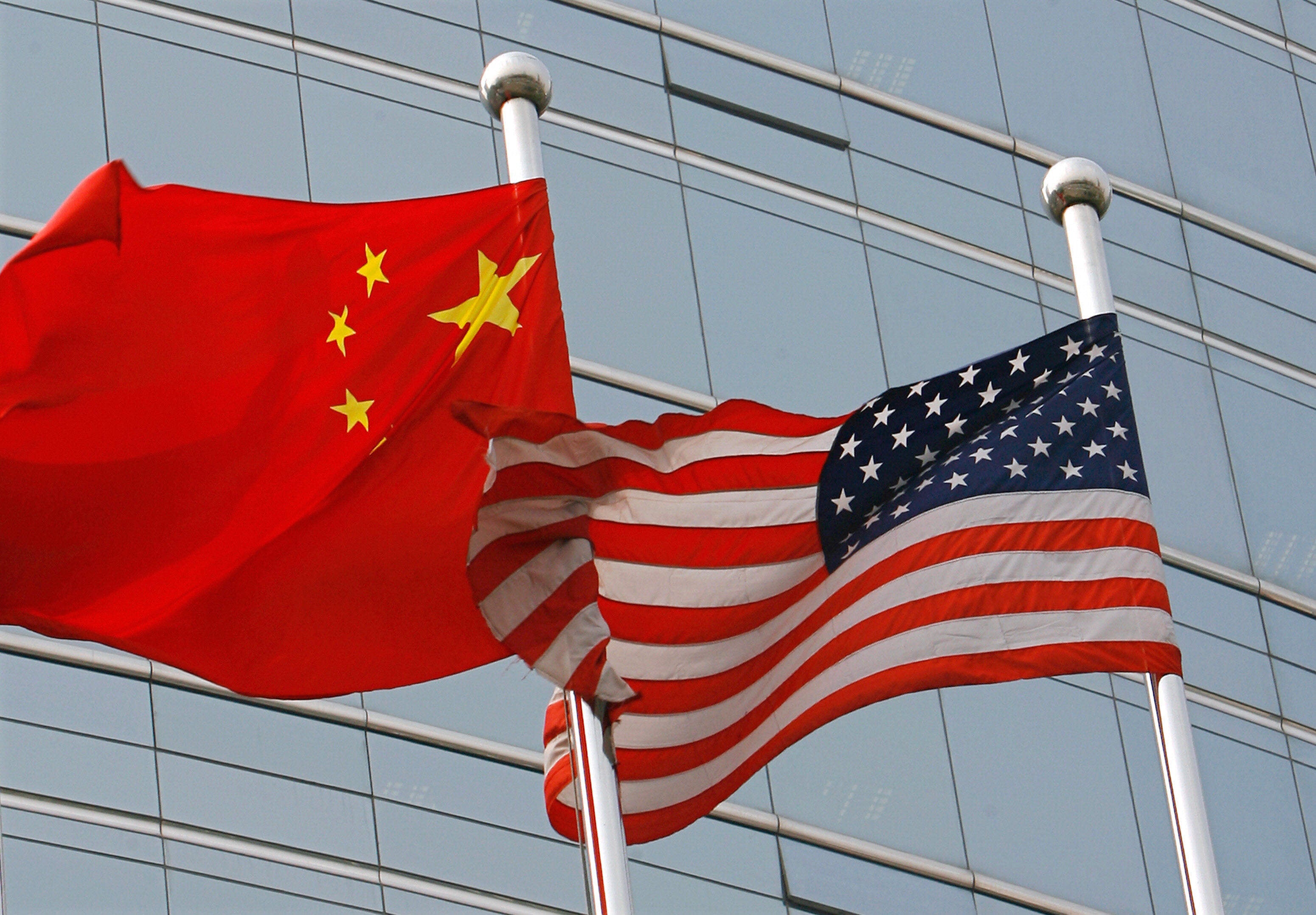 A US and Chinese flag wave outside a commercial building in Beijing. Photo: TNS