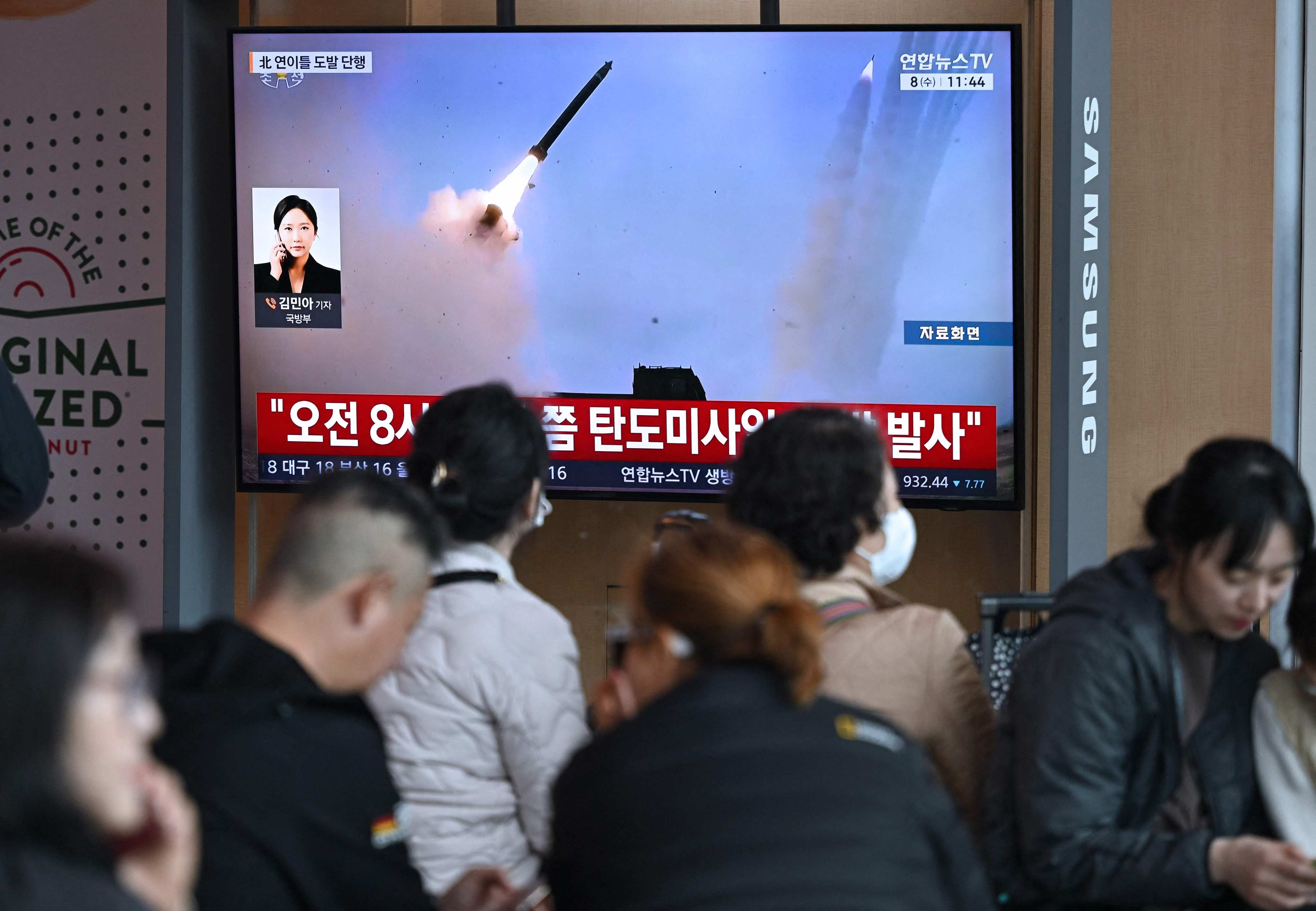 People watch a television screen showing a news broadcast with file footage of a North Korean missile test, at a train station in Seoul in April. Photo: AFP
