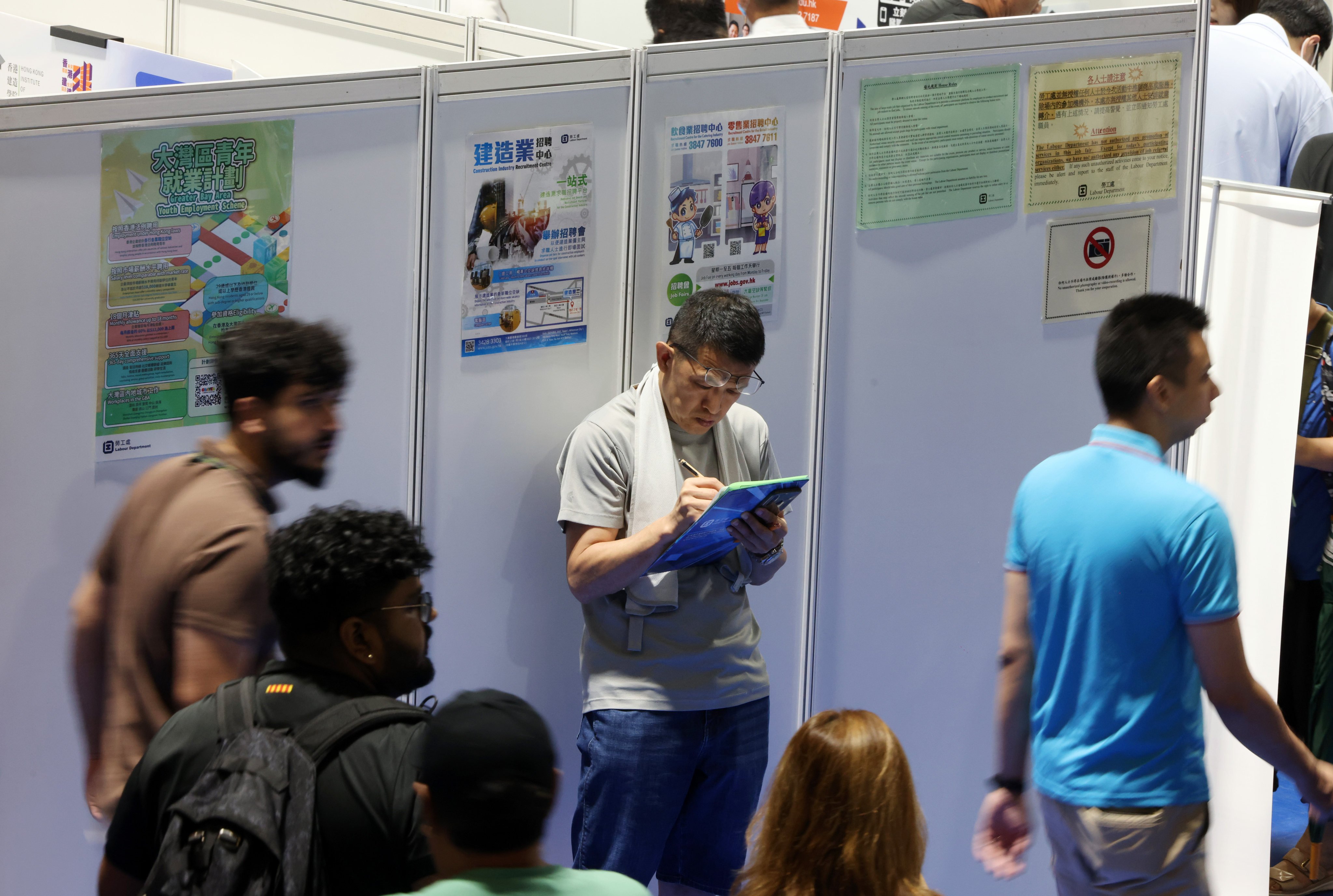 People walk past bilingual posters at the Building a Multicultural Workplace Job Fair held by the Labour Department at MacPherson Stadium in Mong Kok in 2025. Photo: Nora Tam