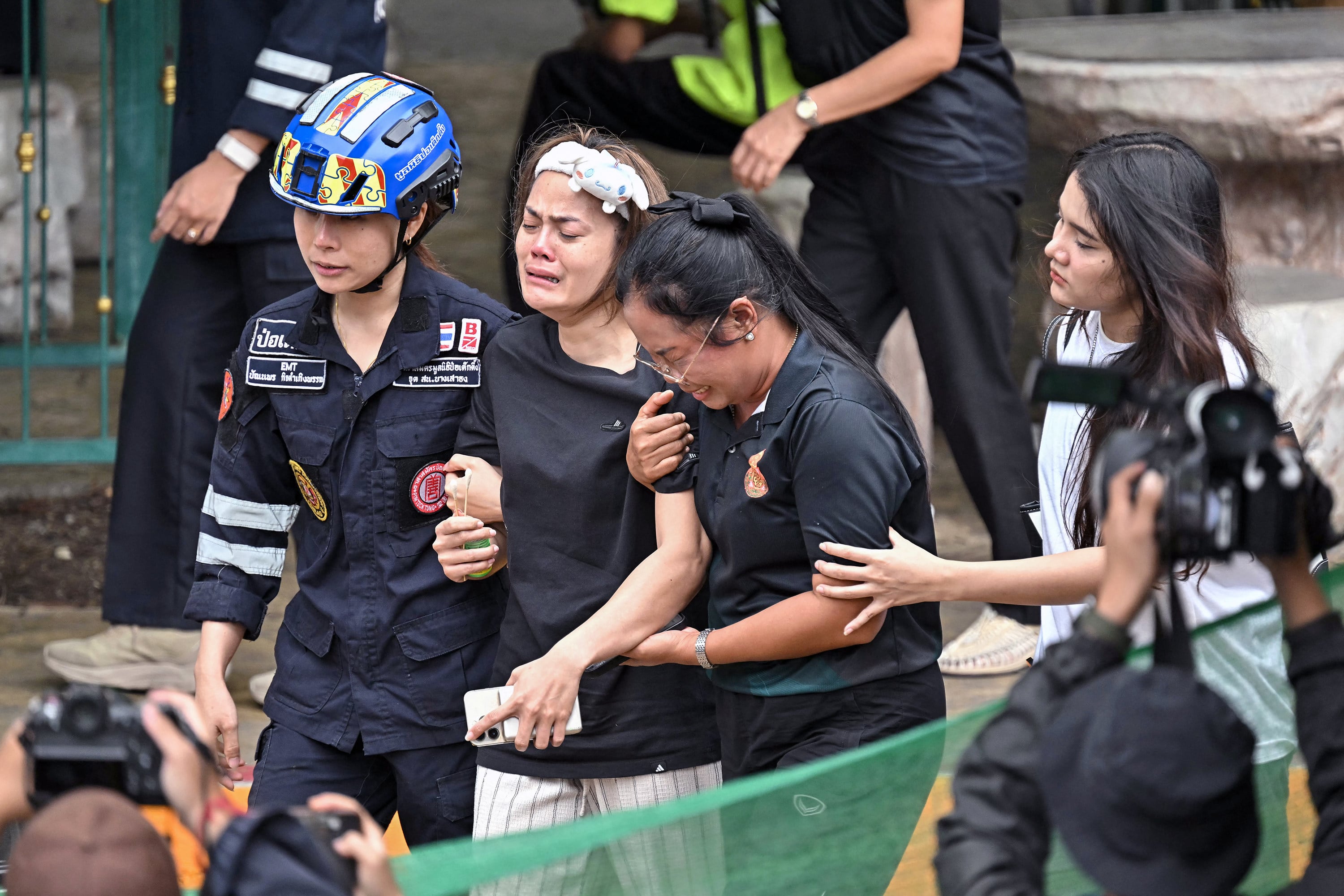 Family members of a teacher who was killed in a school shooting are led to an ambulance in Bang Kruai district, Thailand’s Nonthaburi province, on Friday. Photo: TNS