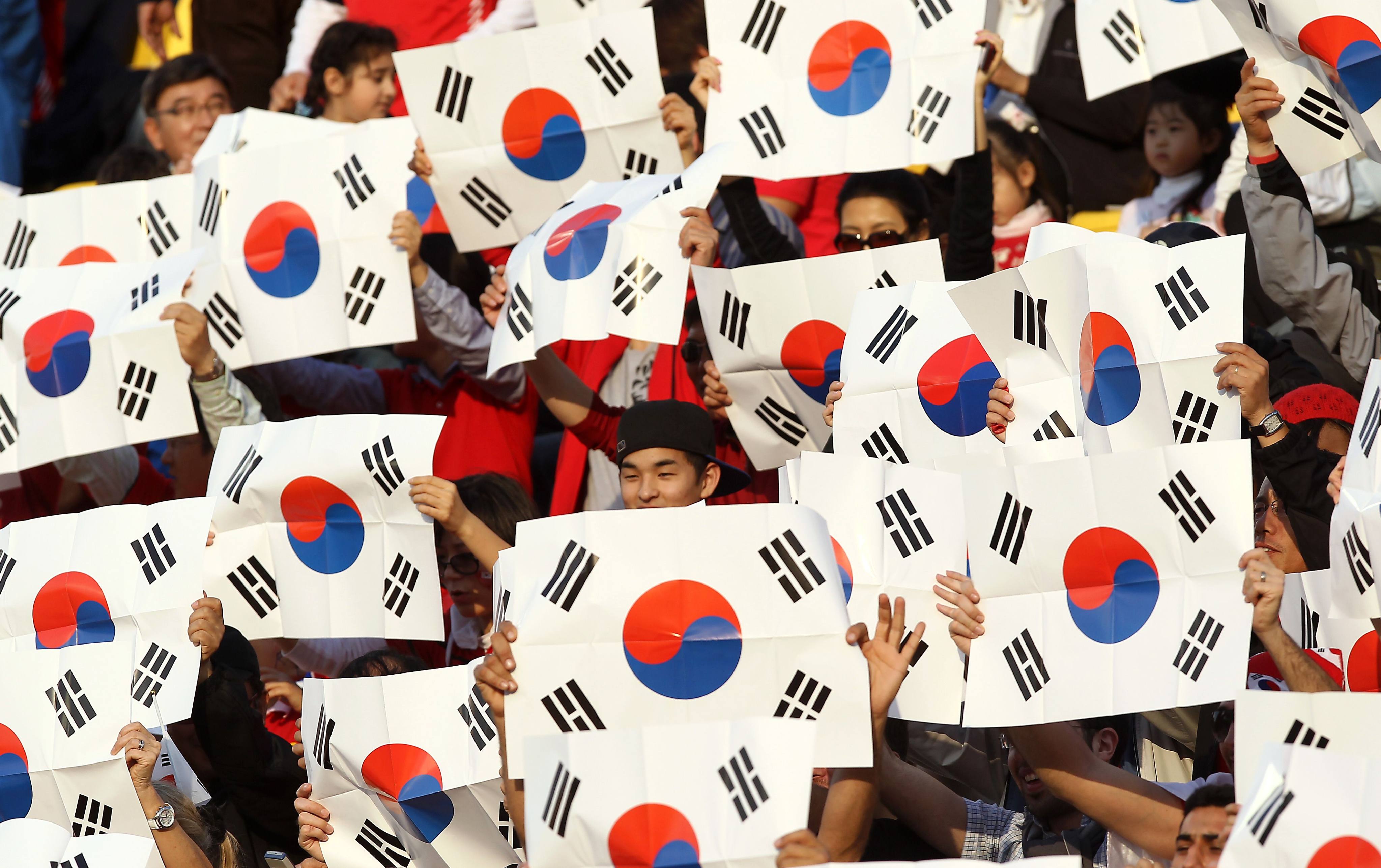 South Korean fans hold national flags as they wait for the start of the 2011 Asian Cup semi-final football match between South Korea and Japan in Doha in 2011. Photo: AFP