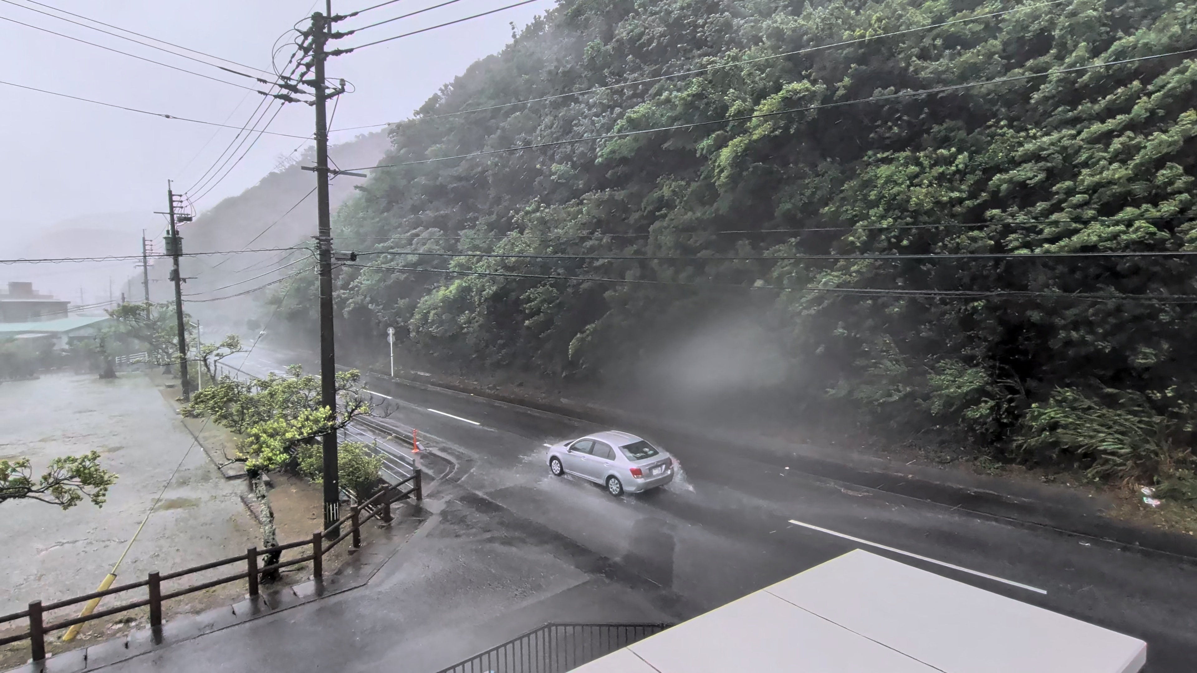 A car makes its way through strong winds and rain. Photo: X/darider5 via Reuters