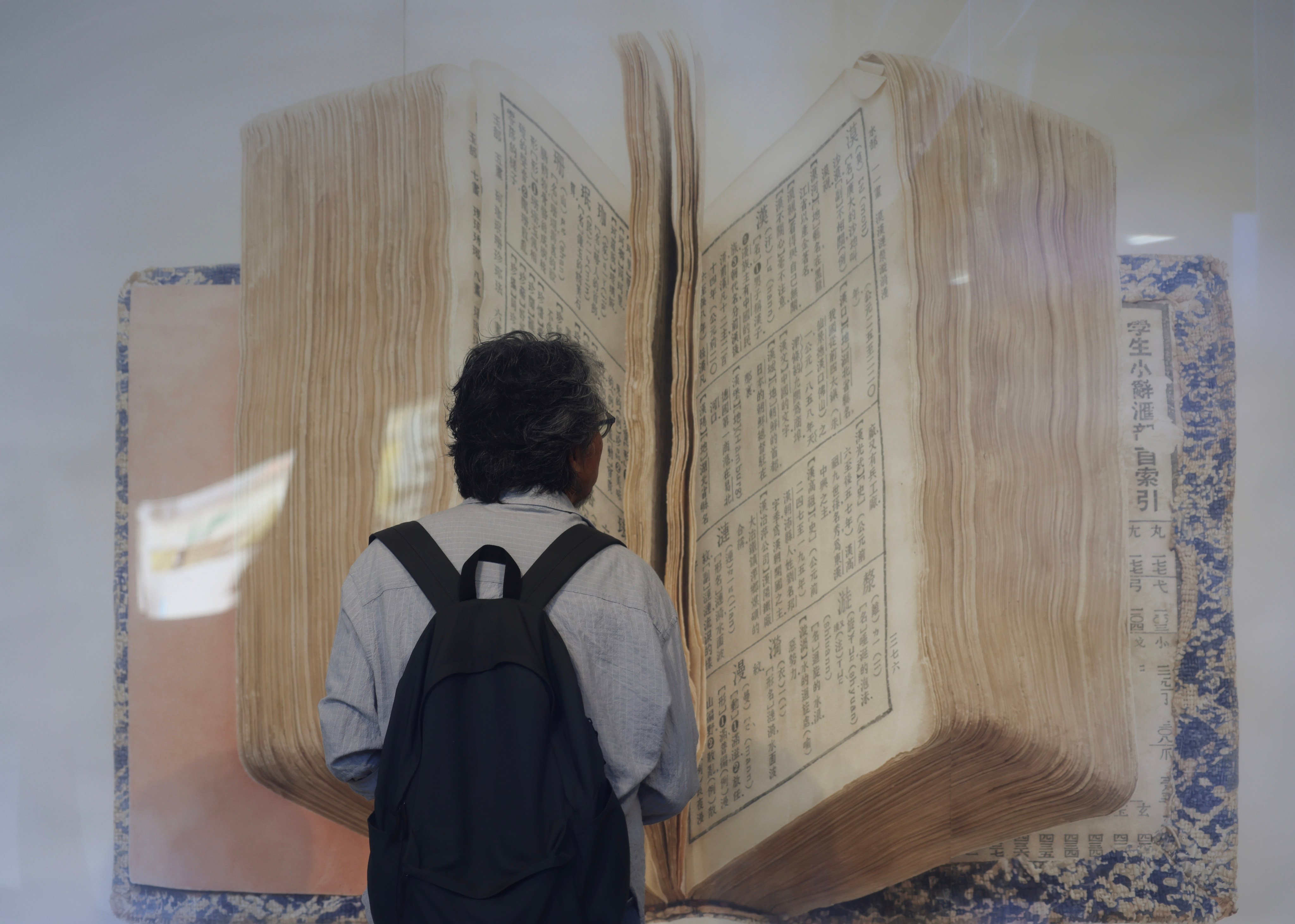 A visitor looks at a large Chinese language dictionary at an exhibition in the West Kowloon Cultural District in Hong Kong on May 12, 2025. Photo: Jelly Tse
