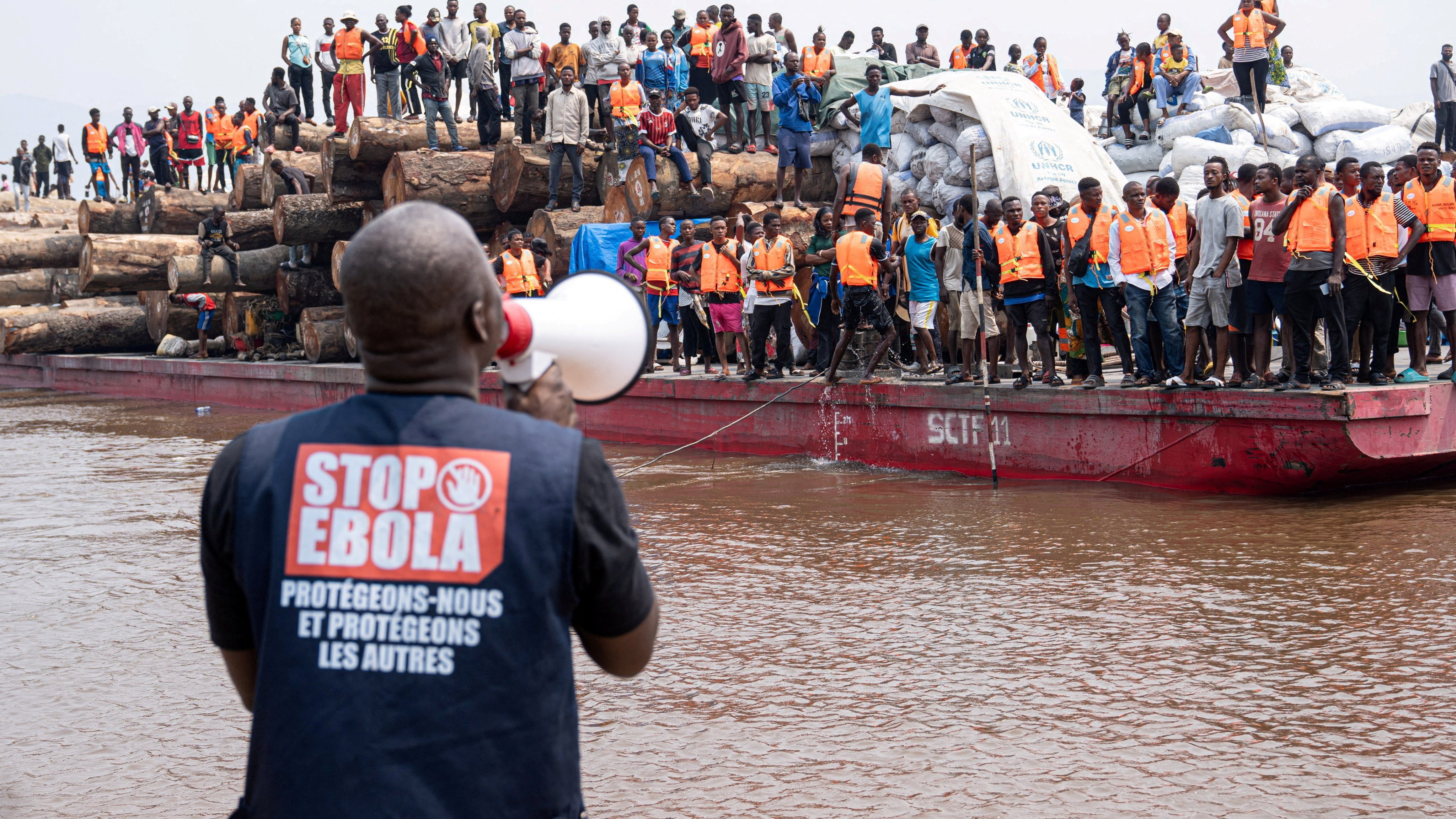 A volunteer uses a megaphone to make announcements while intercepting a passenger boat near Kinshasa, DR Congo, in an image released on Wednesday. Photo: International Organization For Migration via Reuters