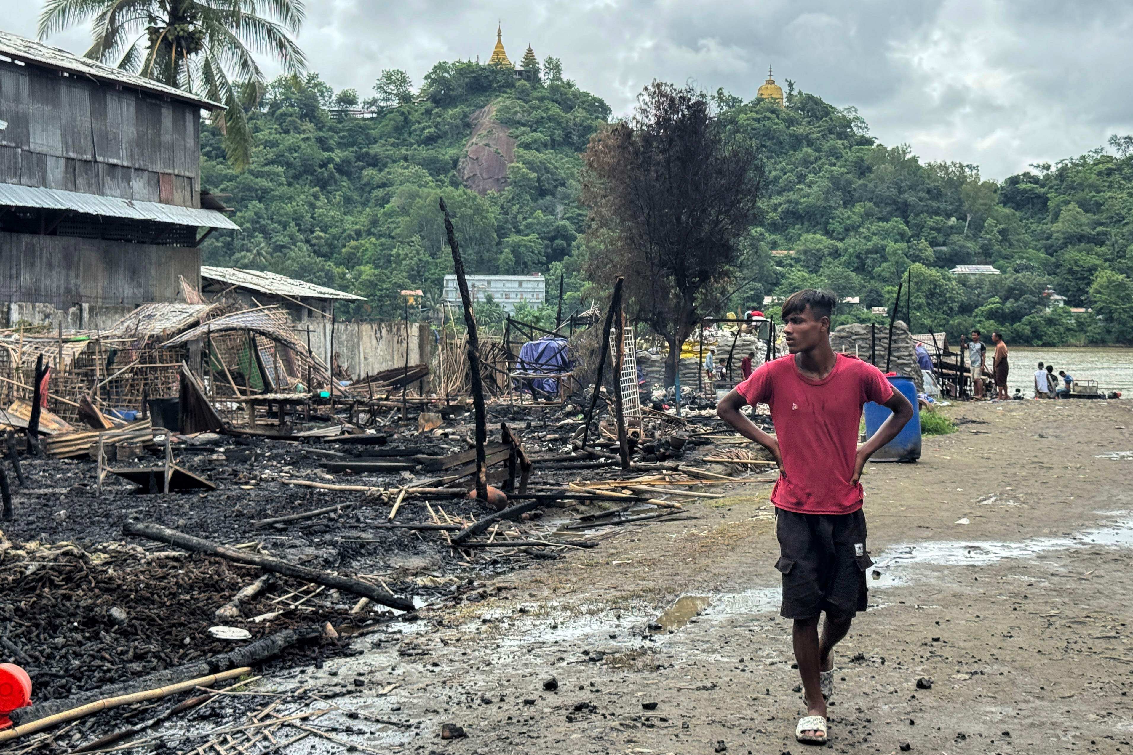 A man walks past the ruins of a building after an airstrike by Myanmar’s military in Kyauktaw, western Rakhine State in June. Photo: AFP