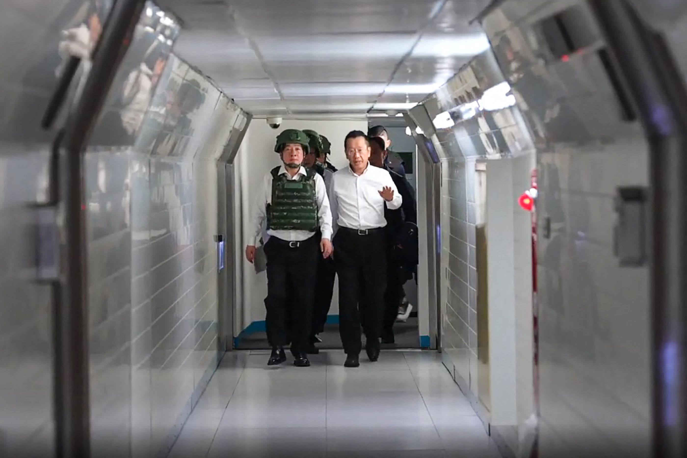 Taiwanese leader William Lai Ching-te (left) wears a bulletproof vest and helmet as he walks through a tunnel to a command centre in Taipei on August 5 as part of the Han Kuang military exercise. Photo: AFP / Presidential Office of Taiwan