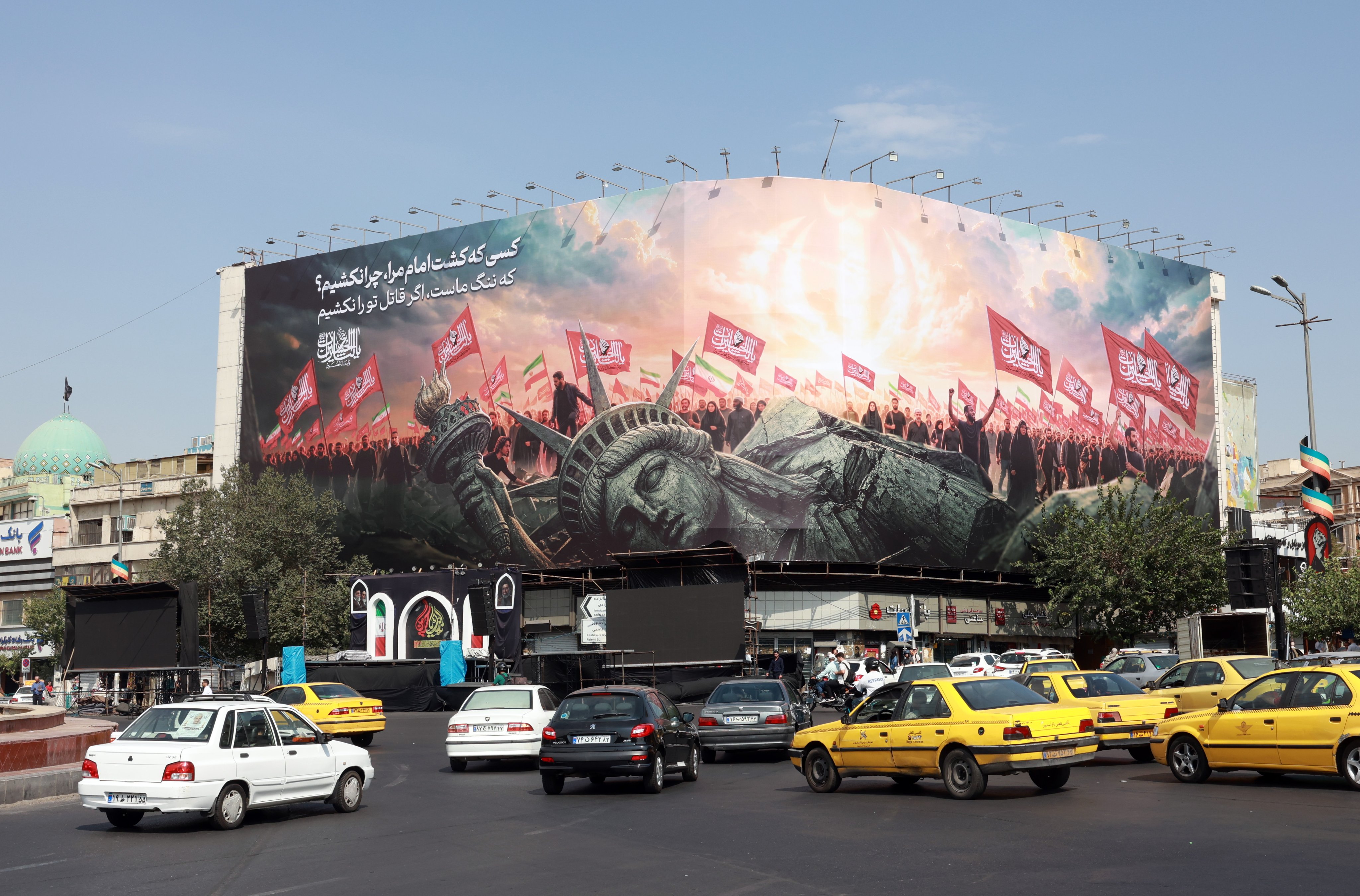 Vehicles drive past an anti-US billboard at Enghelab Square in central Tehran, Iran on Sunday. The Iranian Foreign Ministry said the agreement with Oman would not imply reopening the Strait of Hormuz without the United States accepting the Iranian proposals.  Photo: EPA