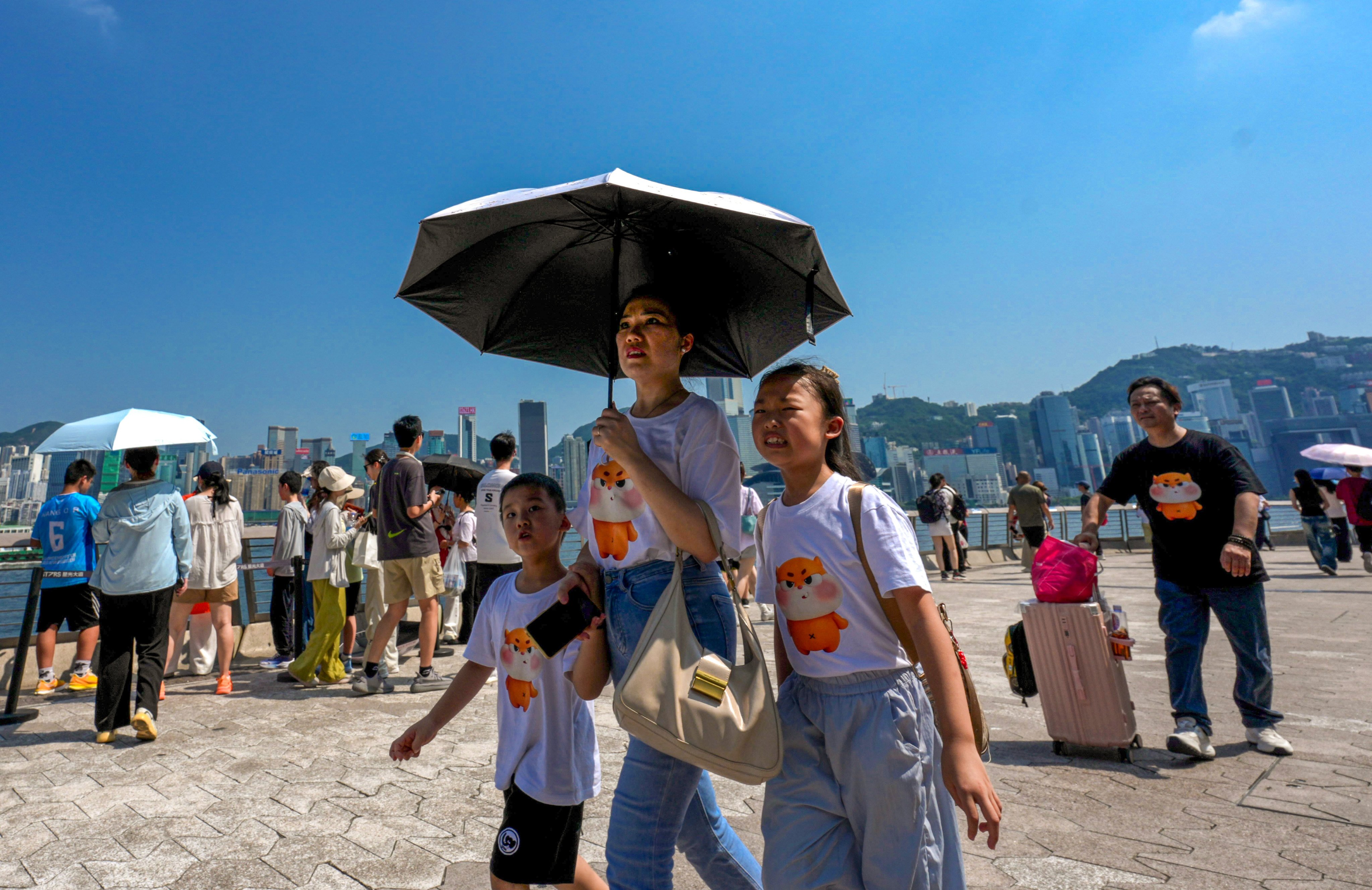 Tourists visit Tsim Sha Tsui in scorching weather. Photo: Jelly Tse