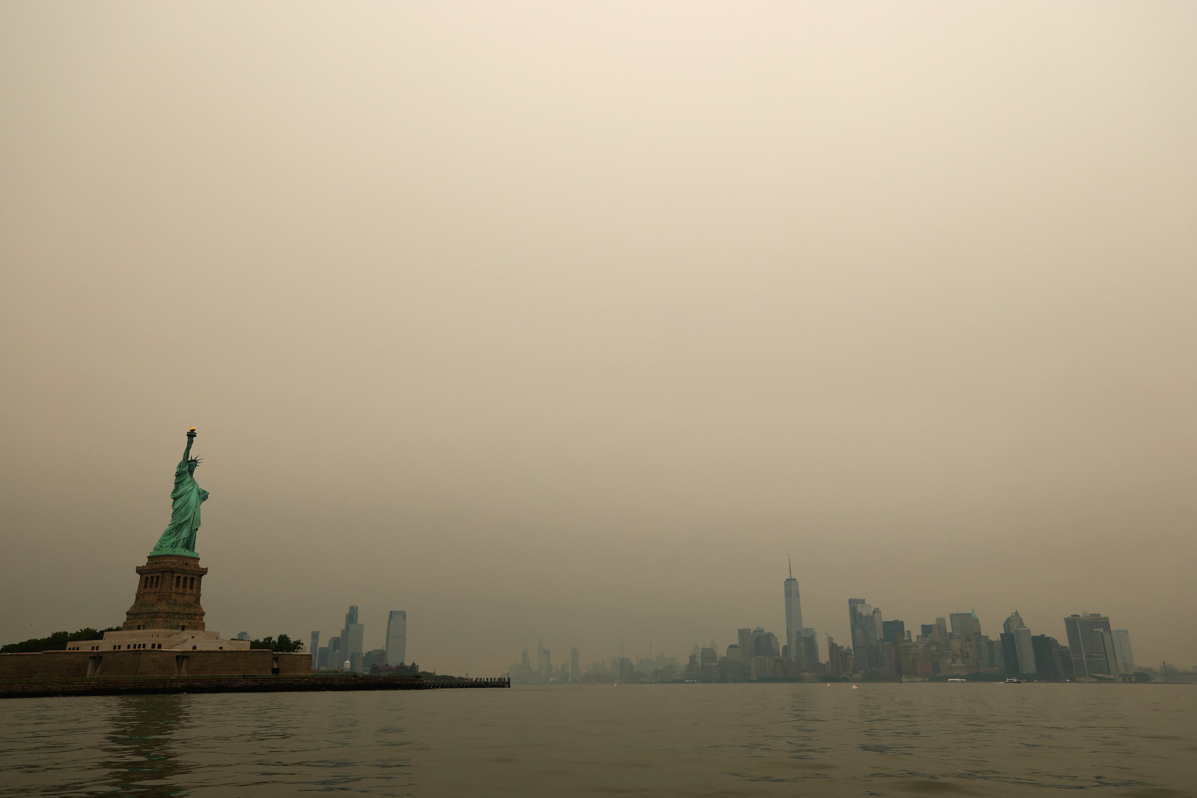 The Statue of Liberty and the New York City skyline are seen through a cover of wildfire smoke from New York Harbour on July 16. Photo: Reuters