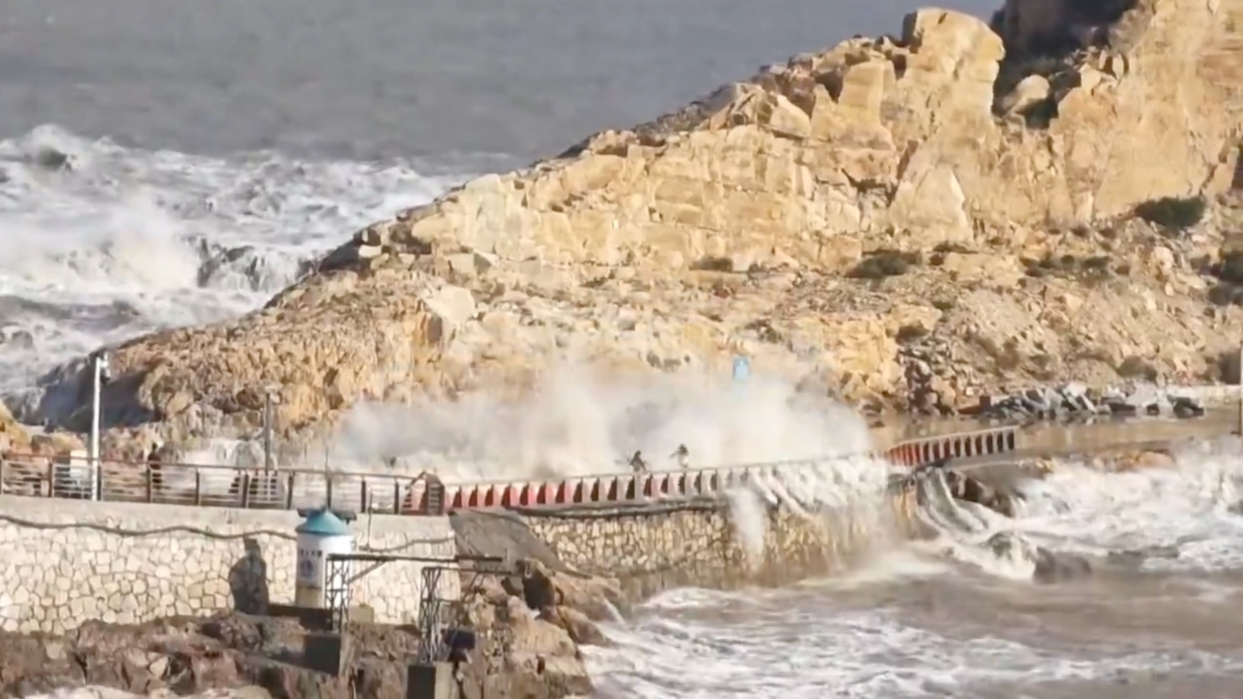 Video footage shows a family of two adults and two children — frantically sprinting across a stone and cement causeway that connects the mainland to a rocky offshore island.  After a colossal wave several metres tall smashed over the path, a nine-year-old boy who has been missing since he was swept away by a giant wave in the eastern Chinese province of Zhejiang. Photo: Handout
