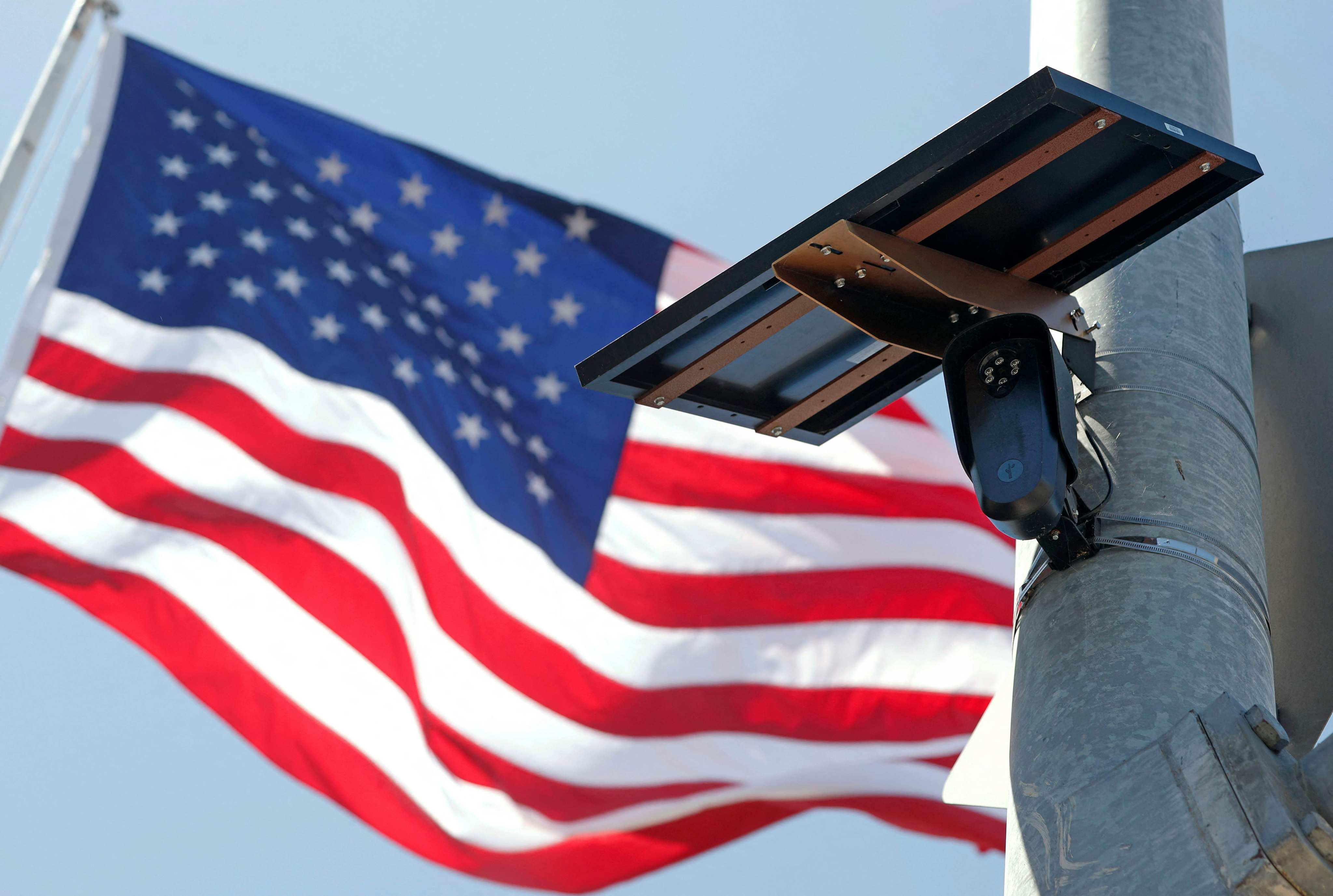 An American flag flies behind a Flock Safety camera mounted to a light pole in Burbank, California. Photo: Getty Images via AFP