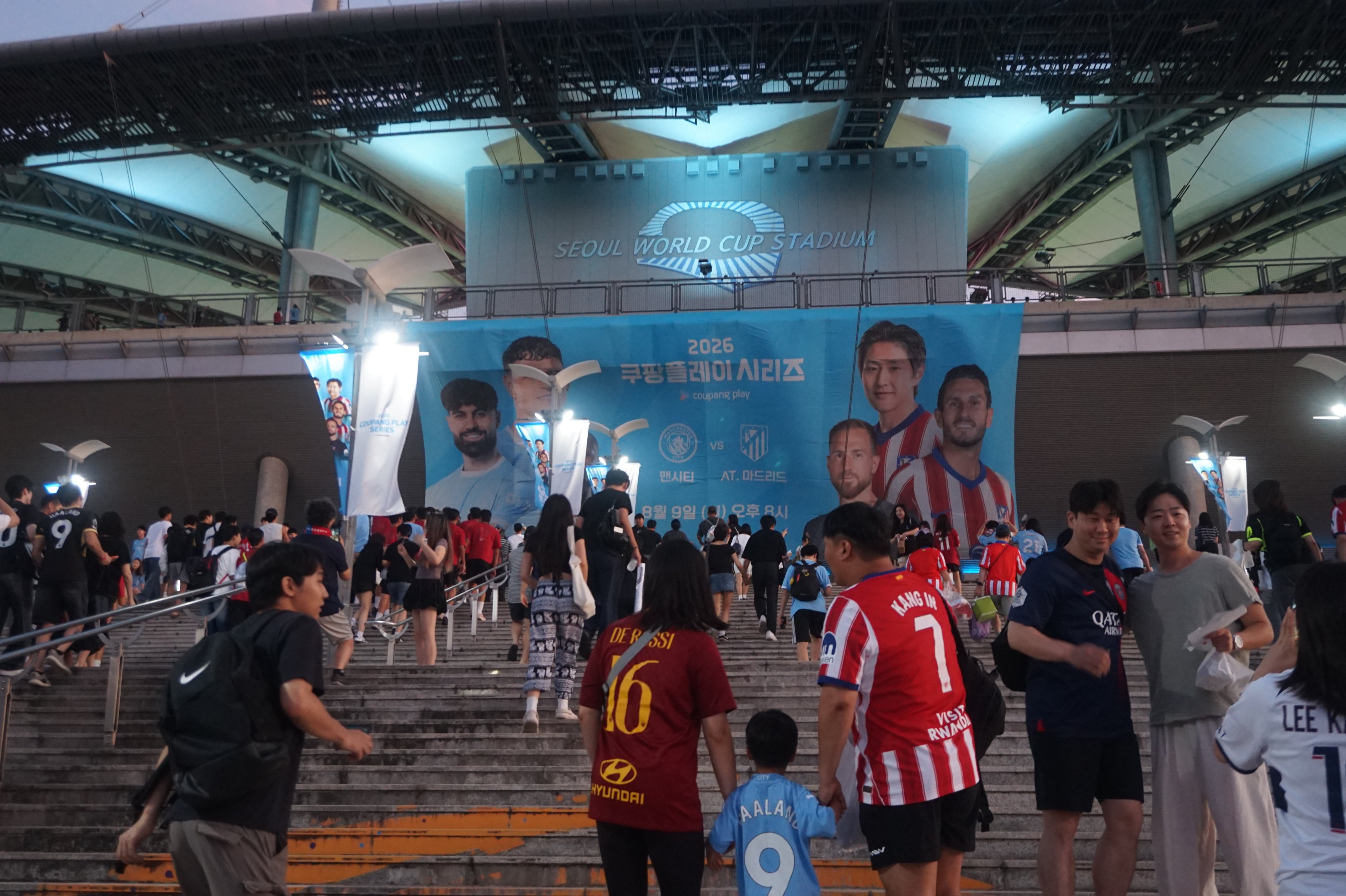 Korean fans wearing European club jerseys take photos in front of the Seoul World Cup Stadium on Sunday, ahead of the friendly match between Manchester City and Atletico Madrid. Photo: David D. Lee