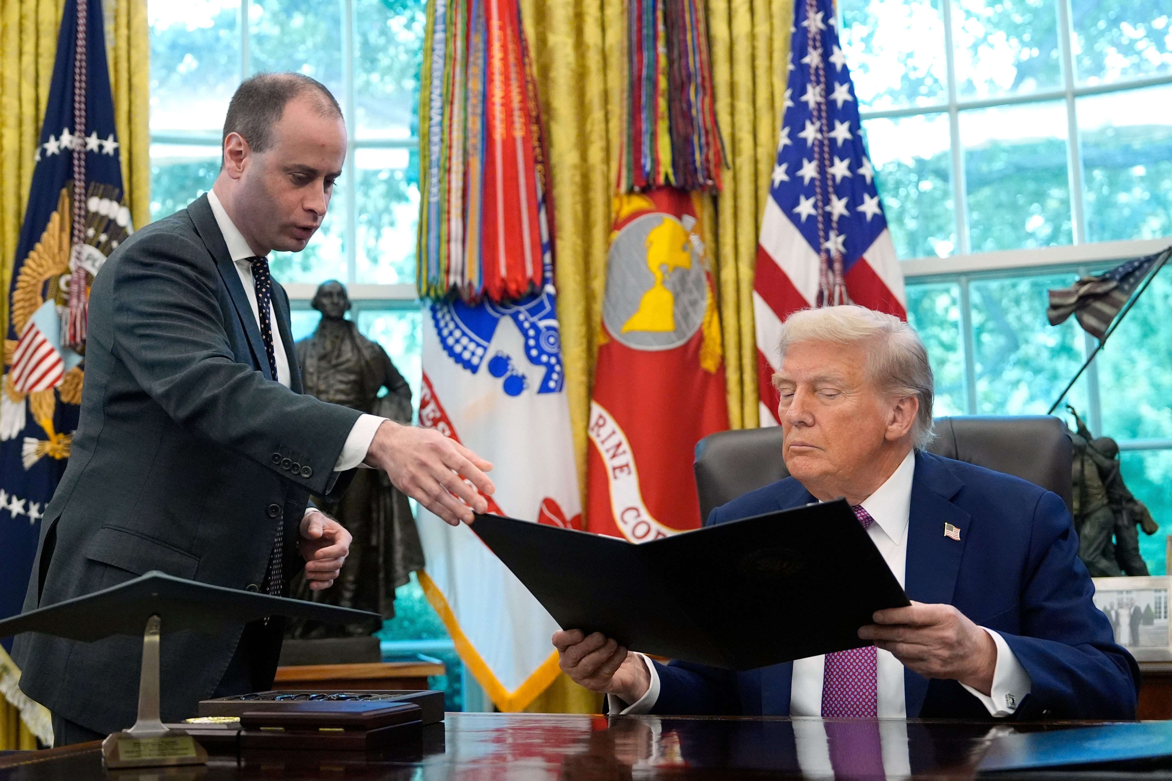 Will Scharf handing President Donald Trump an executive order to sign. Photo: AP