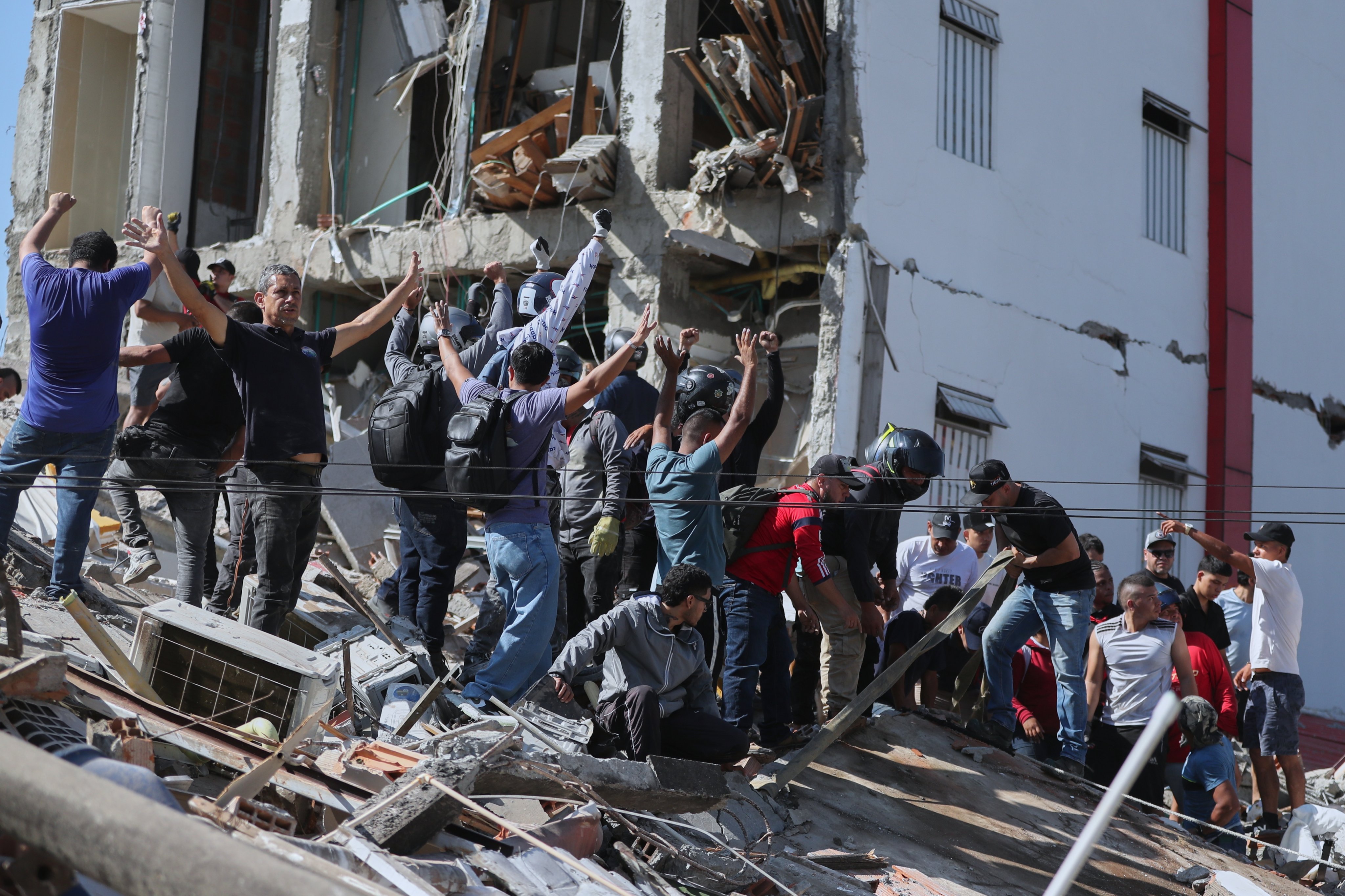 Residents and rescuers search through the rubble of a collapsed building after an earthquake struck Cali, Colombia on Monday. Photo: AP