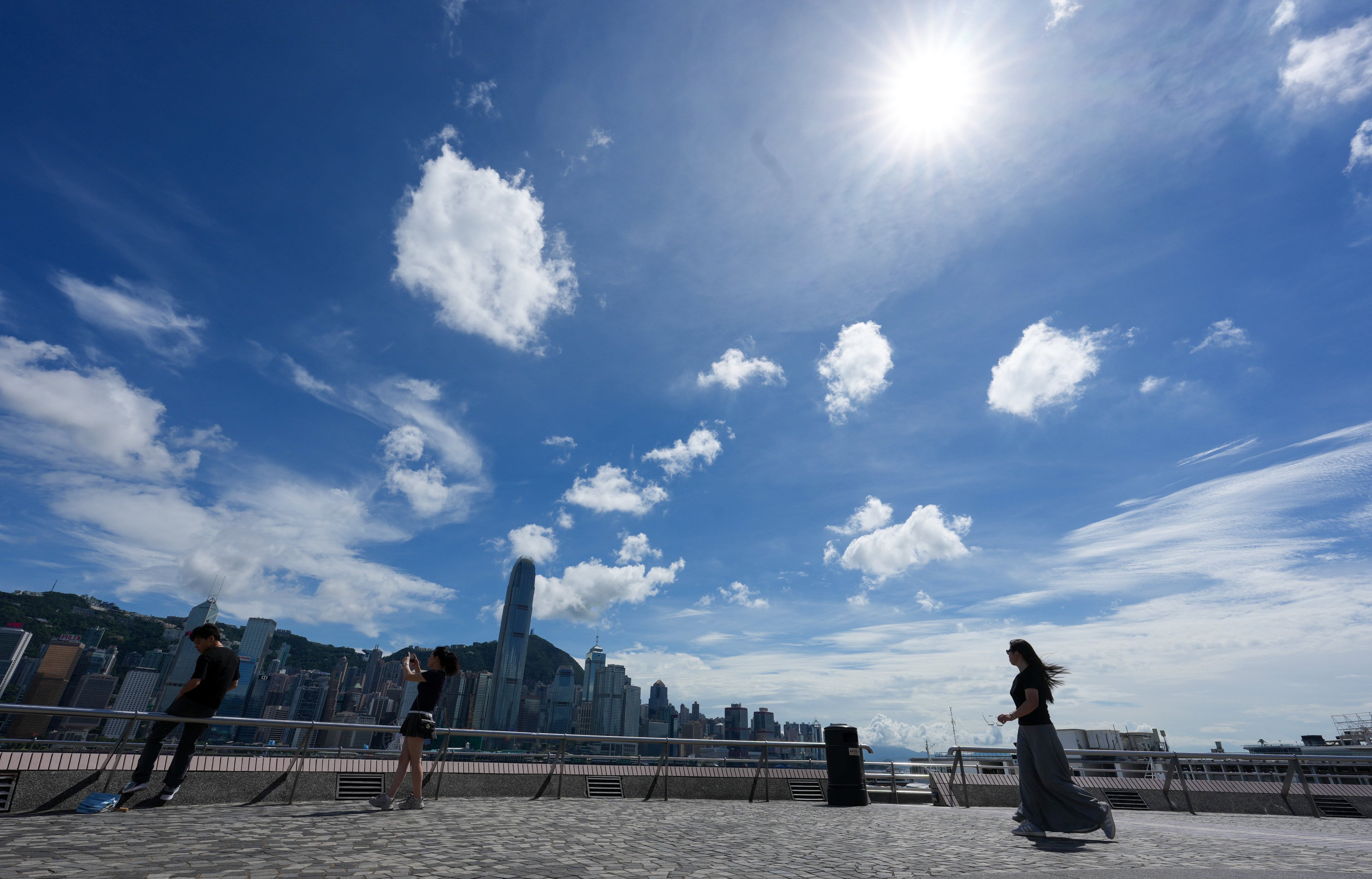 Pedestrians walk in view of the city skyline at Tsim Sha Tsui waterfront on June 30. As mainland China emerges as a superpower, Hong Kong must change with the rest of the nation, and for the better. Photo: Jelly Tse