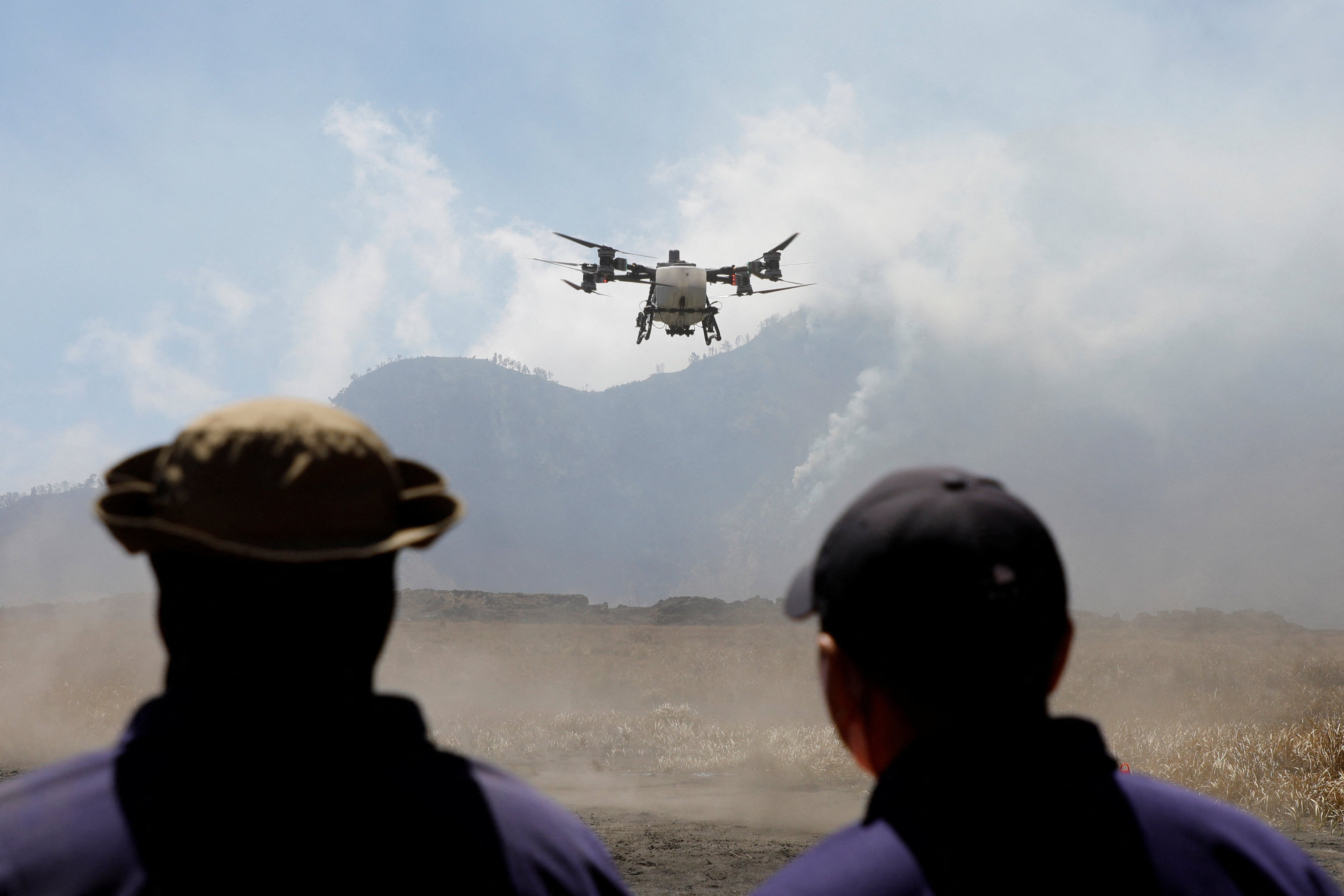 East Java disaster mitigation agency personnel deploy a water spraying drone to fight a wildfire at Mount Bromo National Park on Sunday. Photo: Reuters