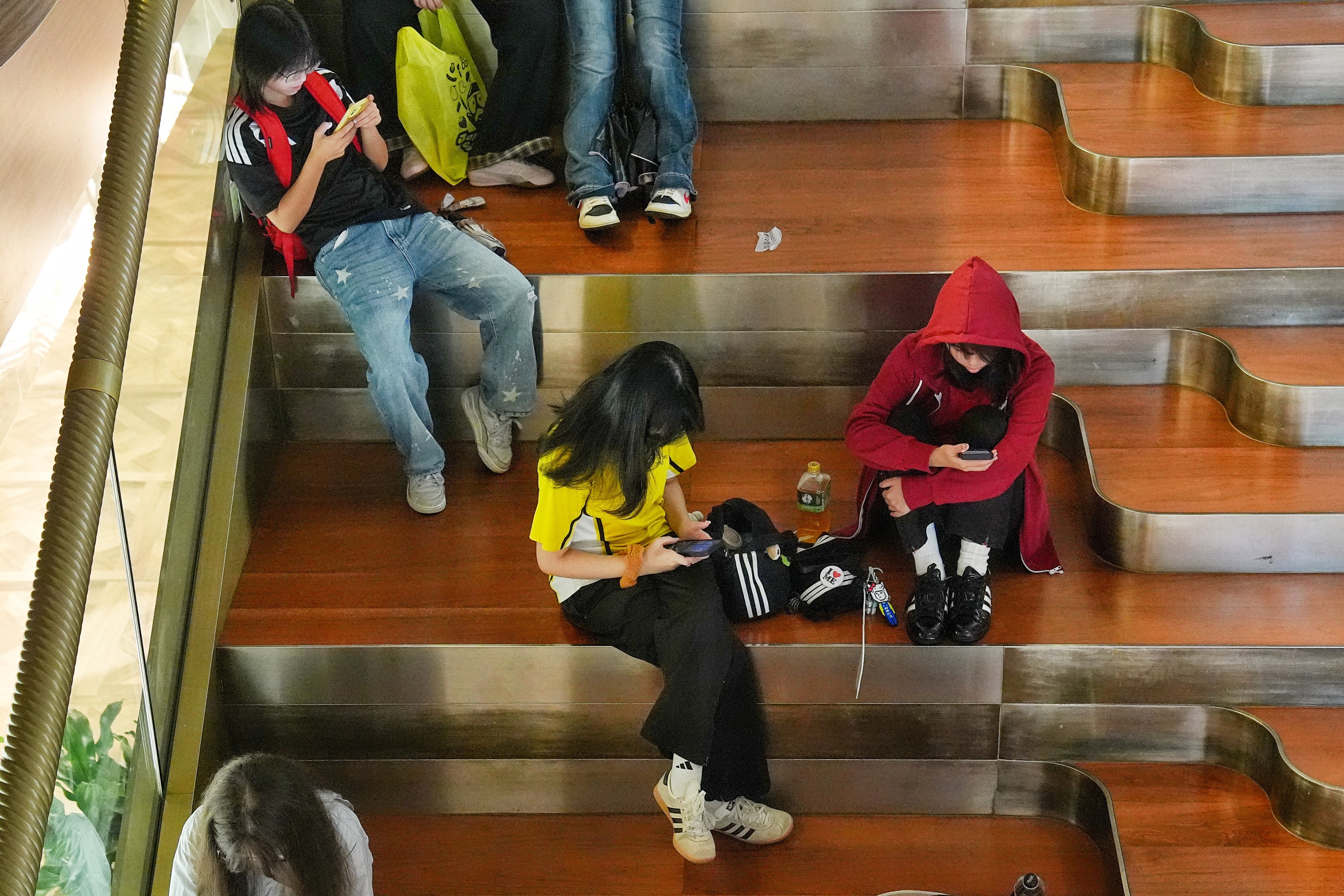 Young people use their mobile phones at a seating area of a shopping mall in Tsim Sha Tsui. Photo: Elson Li