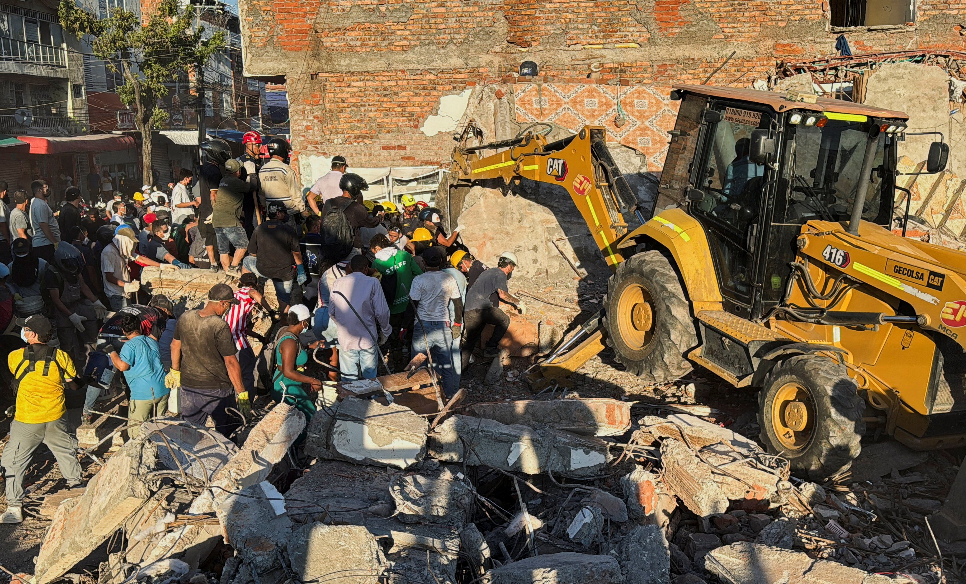 Residents and emergency personnel dig through the debris of a collapsed building in Cali, Colombia, on Monday. Photo: Reuters