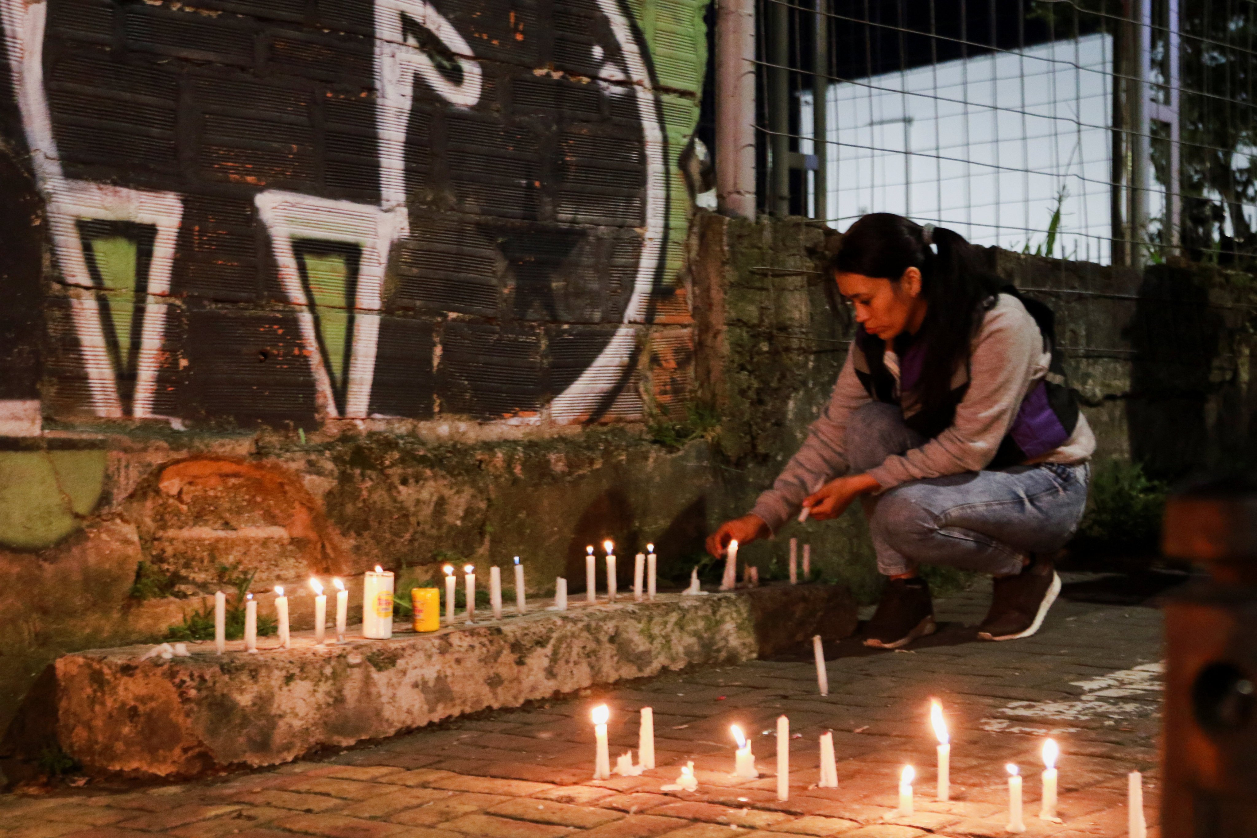 A woman lights candles on a street following an earthquake in Manizales, Colombia, on Monday. Photo: Reuters