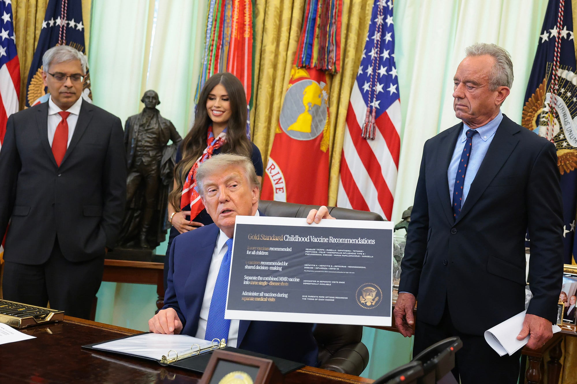 US President Donald Trump holds up a sign that says “Gold Standard Childhood Vaccine Recommendations” before signing an executive order. Photo: Getty Images/TNS