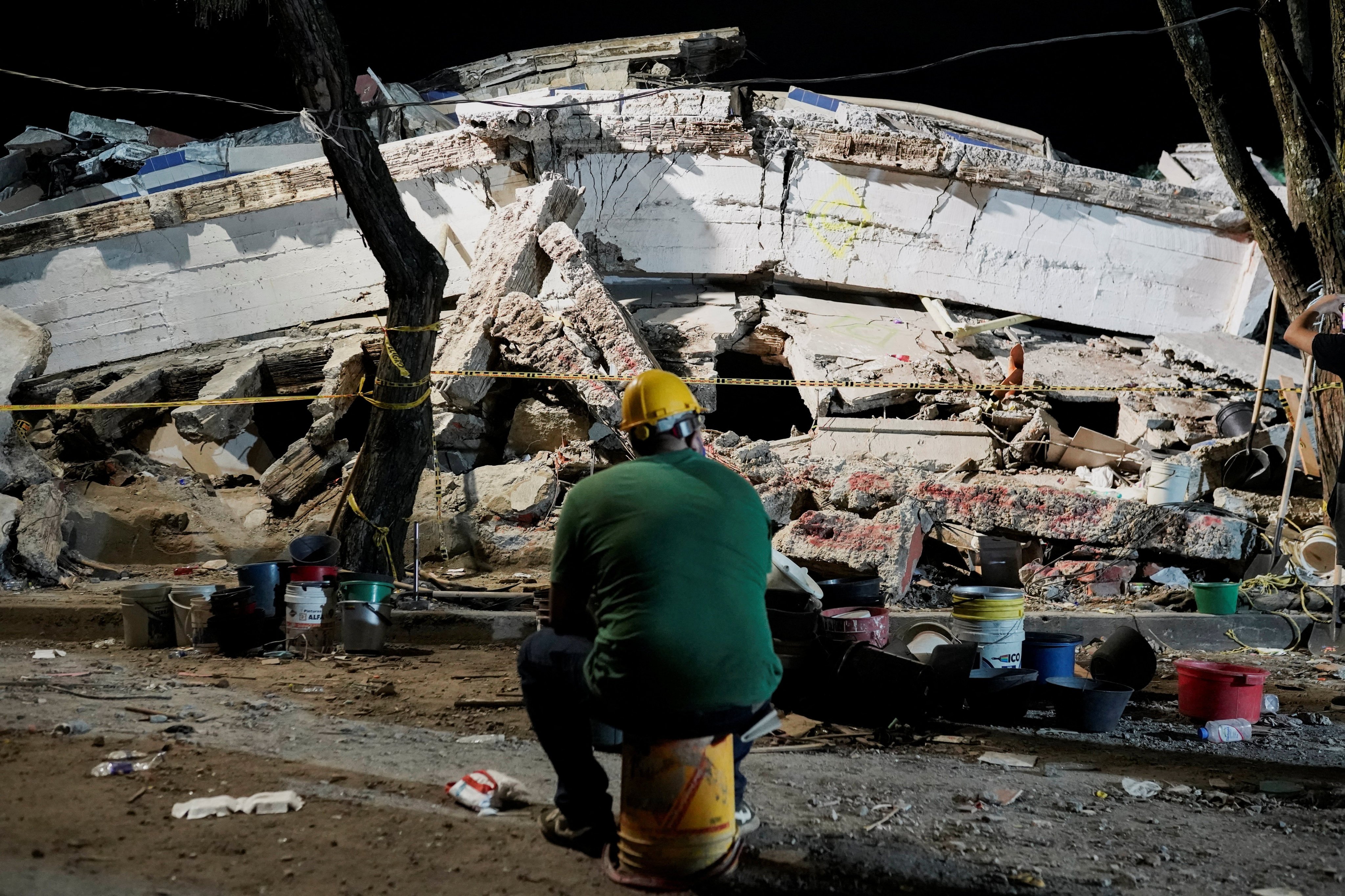 A man sits near debris in Cali, Colombia. Photo: Reuters