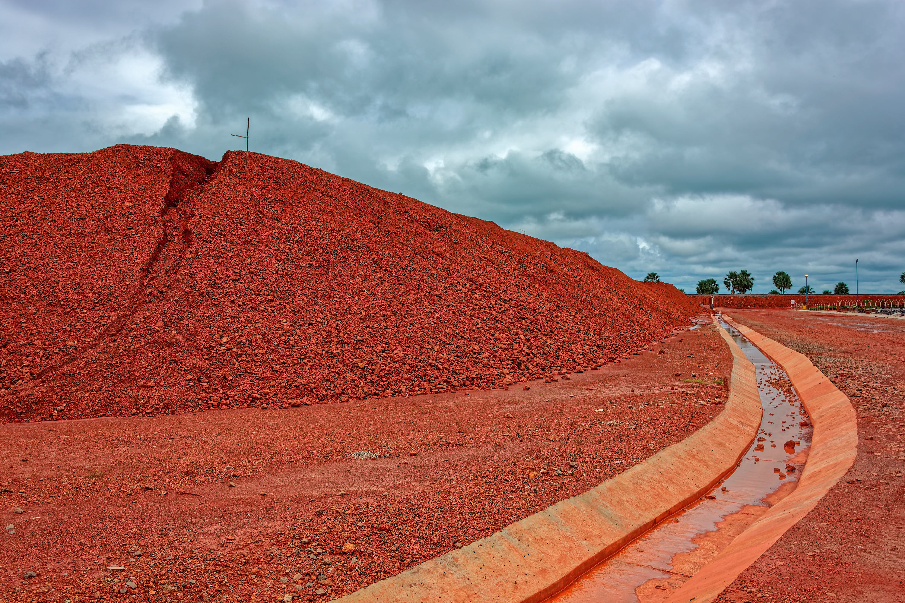 Large piles of bauxite ore, which is refined into aluminum, sit at a treatment area storage in Guinea. Photo: Shutterstock