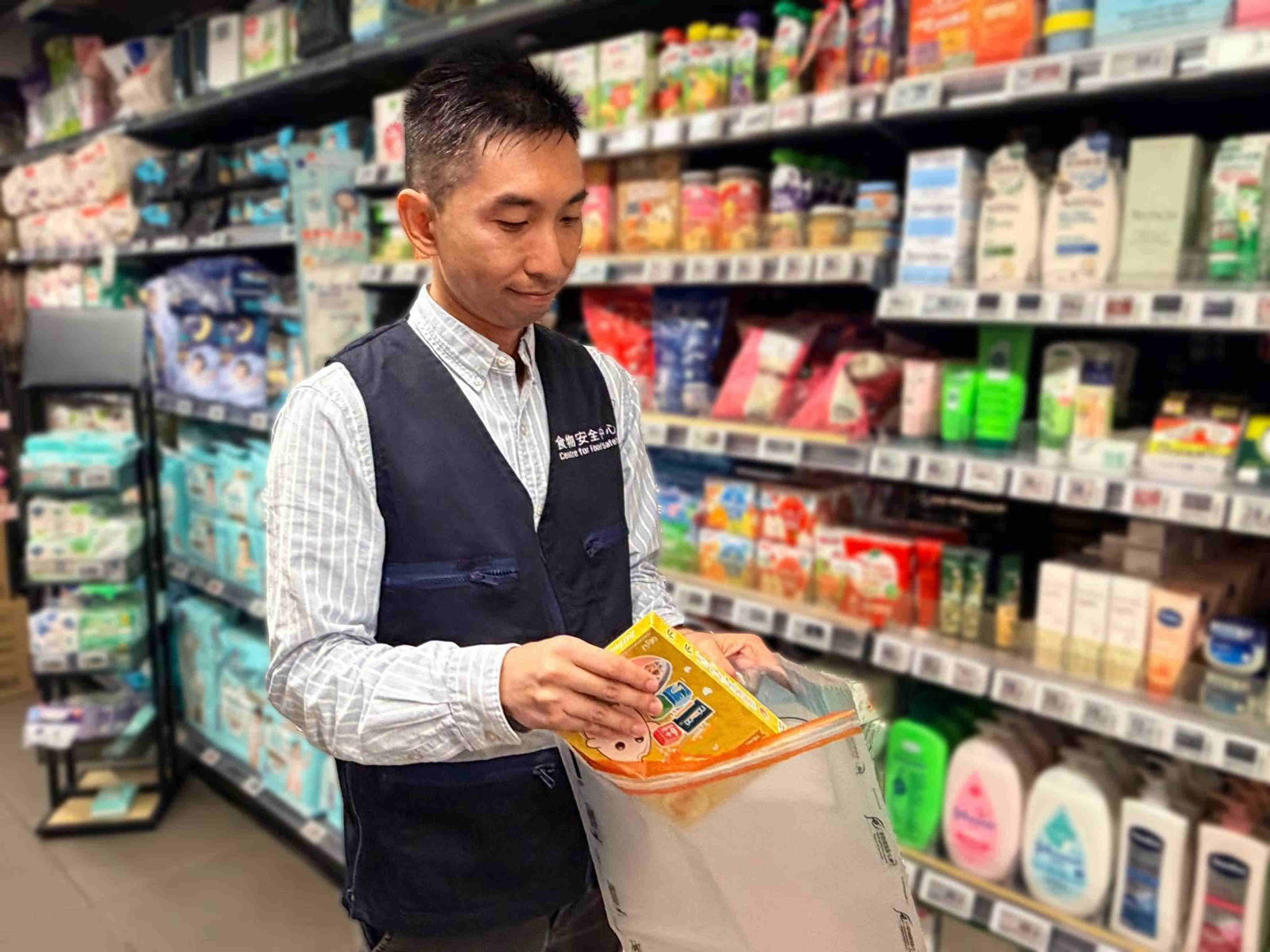 An officer of the Centre for Food Safety collects samples from the market for investigation. Photo: Handout