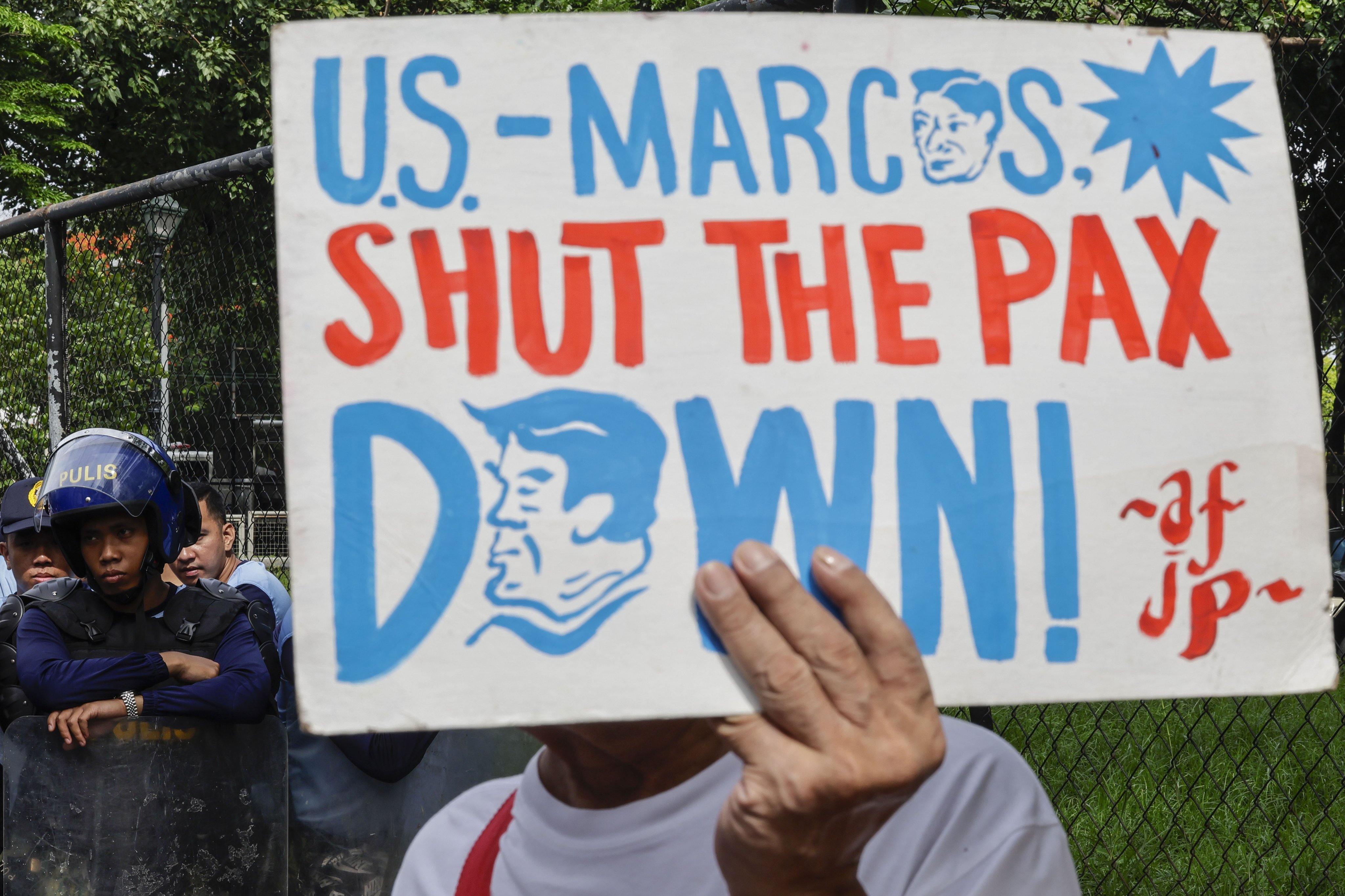 A protester holds a sign during a rally on a road leading to the US embassy in Manila on July 13, expressing opposition to Philippines-US defence agreements and the US-led Pax Silica initiative. Photo: EPA