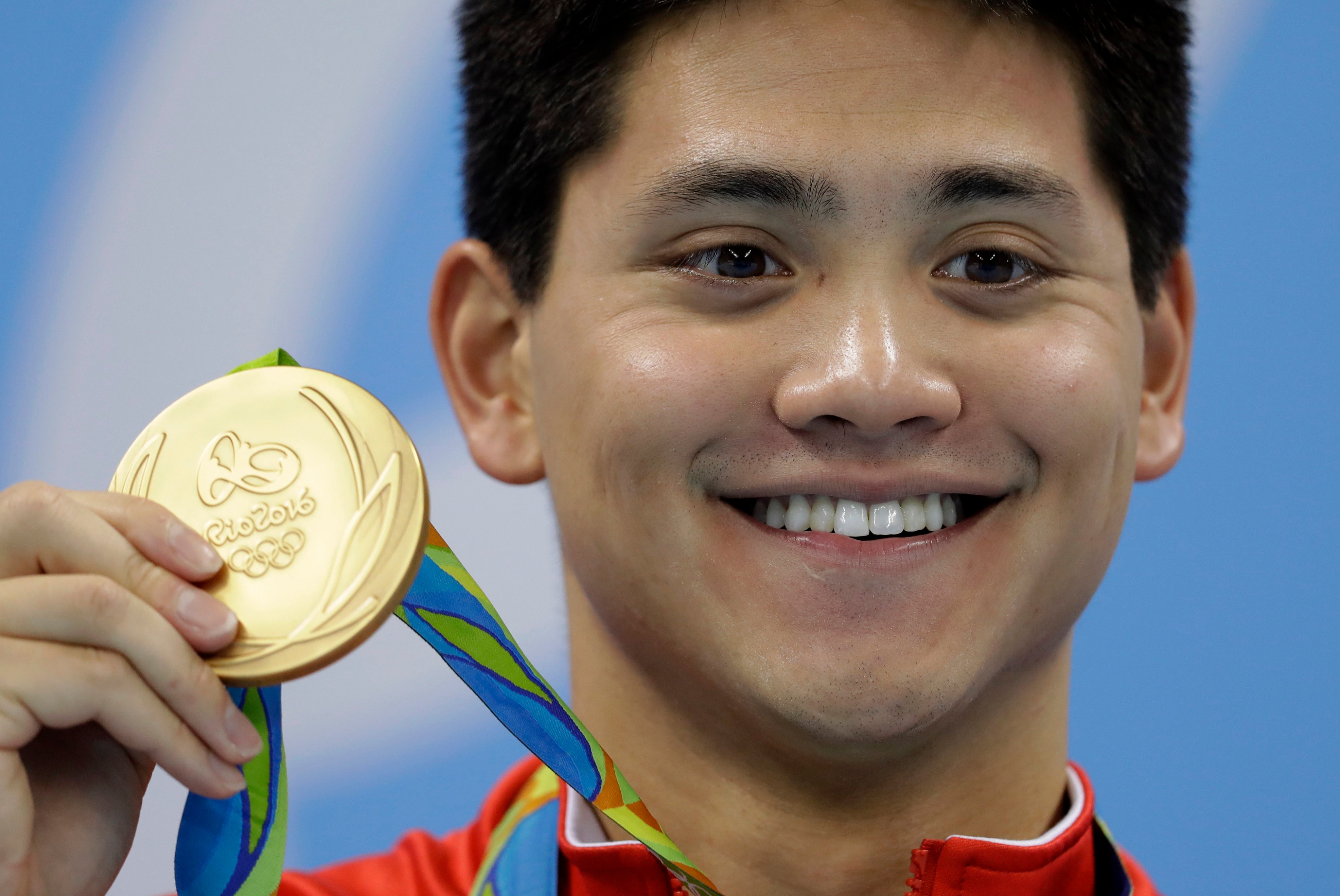 Singapore’s Joseph Schooling shows off his gold medal in the men’s 100-meter butterfly medals ceremony during the swimming competitions at the 2016 Olympics on August 12, 2016. Photo: AP