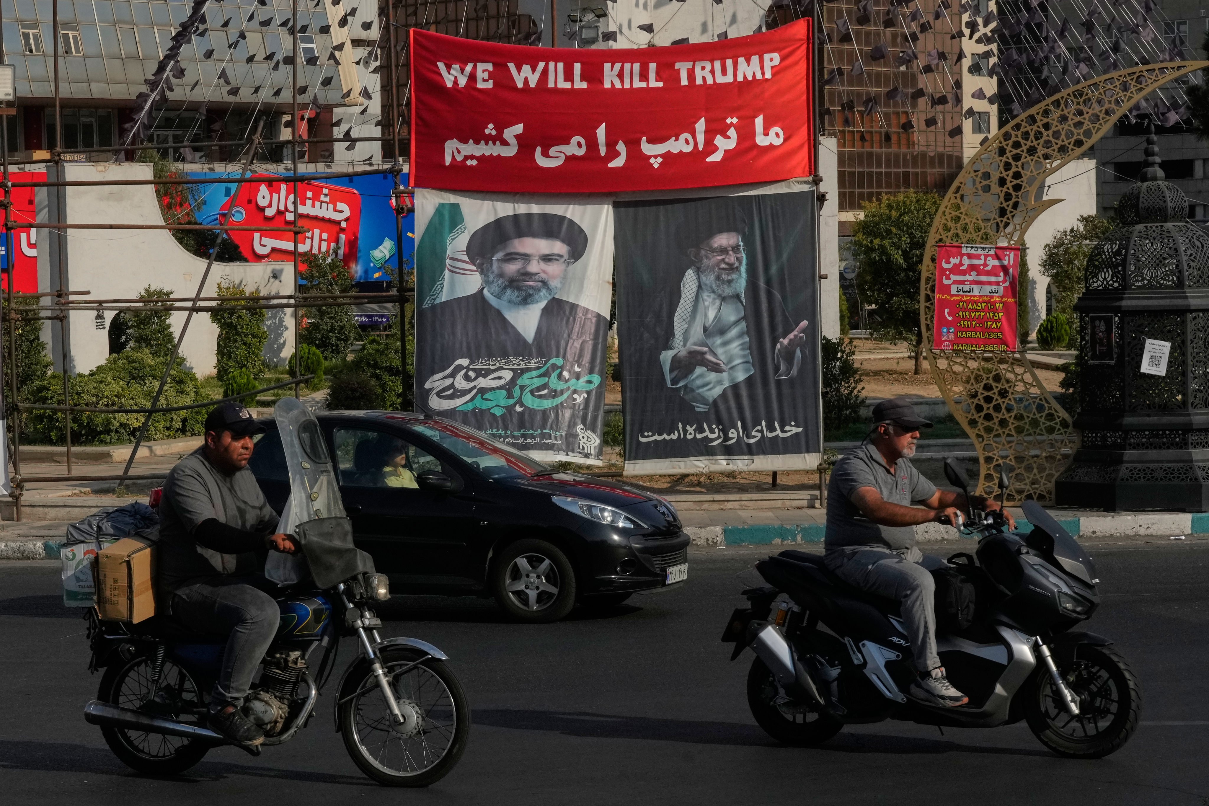 Vehicles drive past banners showing portraits of Iran’s Supreme Leader Mojtaba Khamenei and his father at a square in Tehran on Monday. Photo: AP