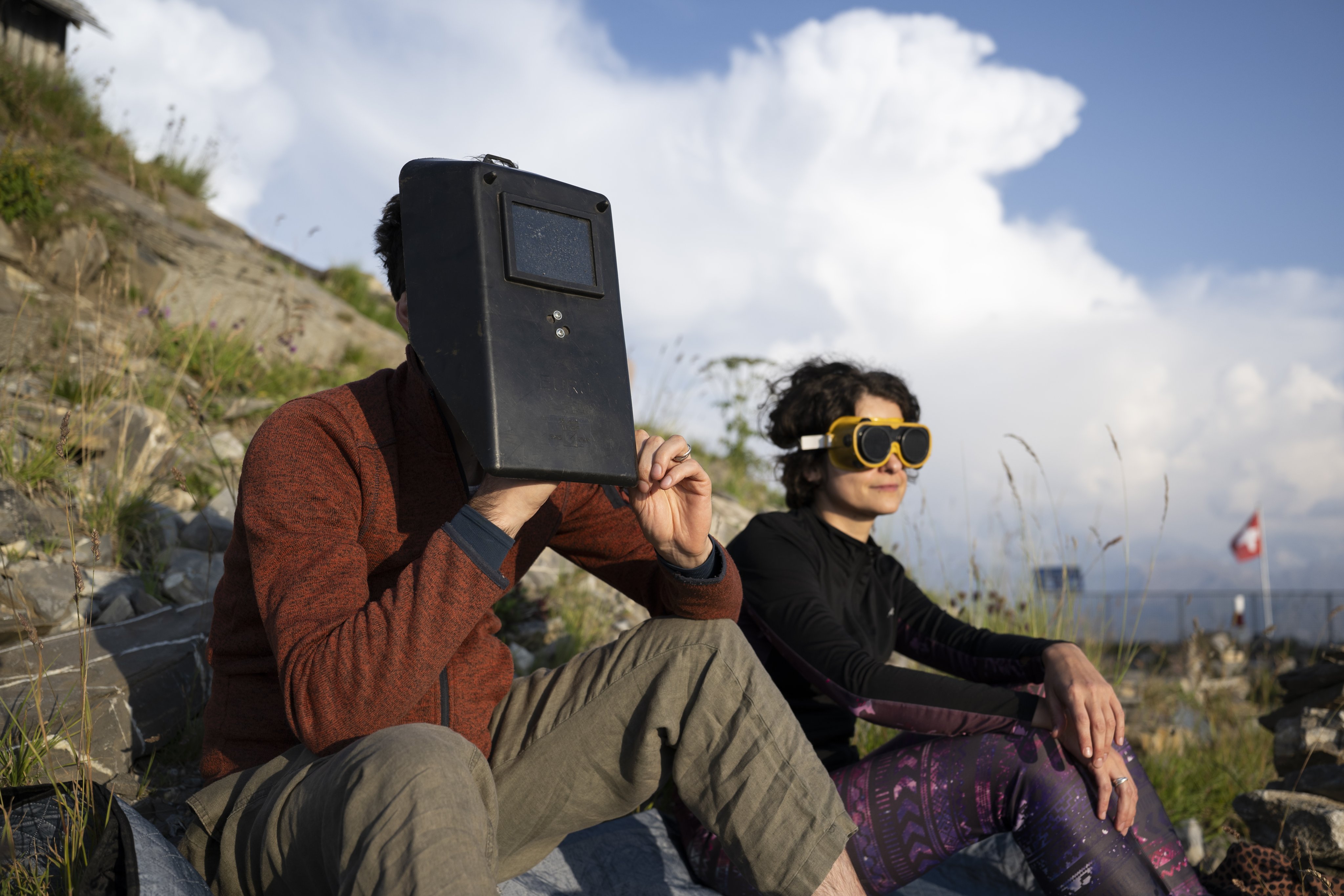 People wear protective equipment while watching the partial solar eclipse from the summit of Niesen in the Bernese Oberland, Switzerland, on Wednesday. Photo: EPA