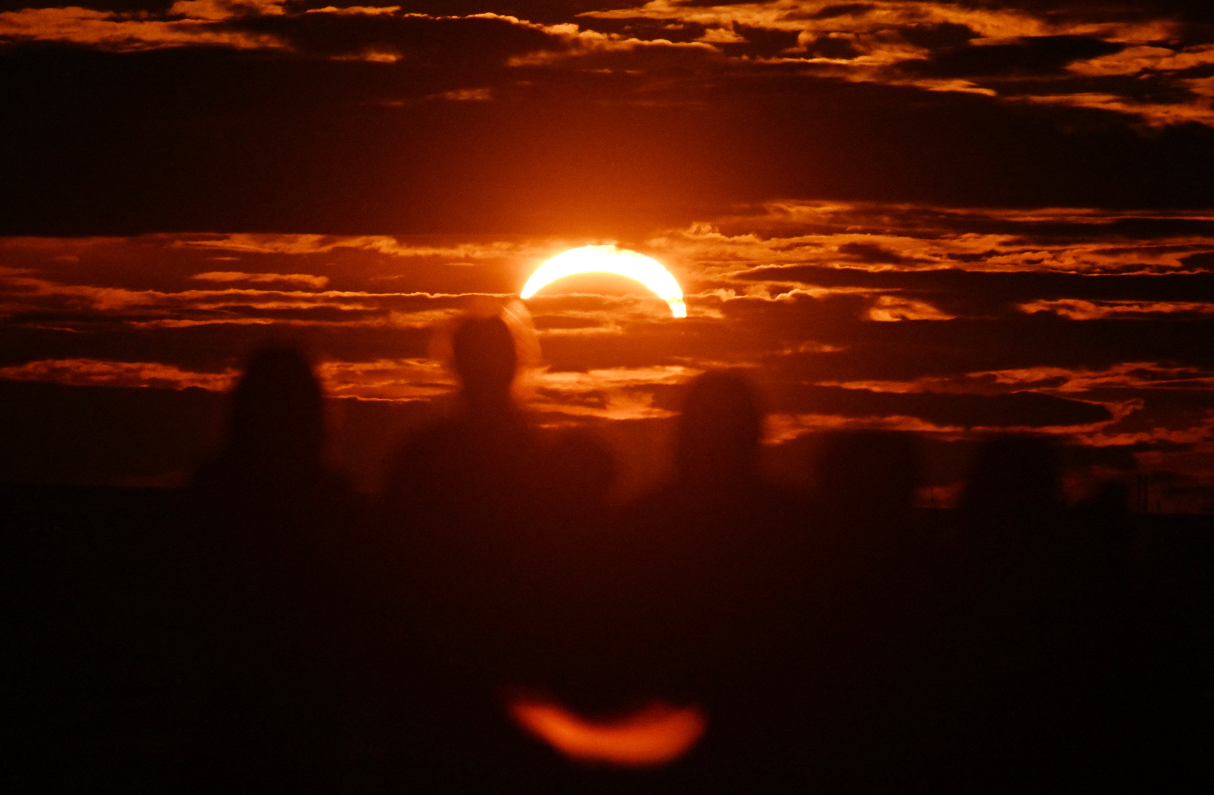 The moon passes in front of the sun as it sets during a partial solar eclipse in Saint Petersburg on August 12, 2026. (Photo by Olga MALTSEVA / AFP)