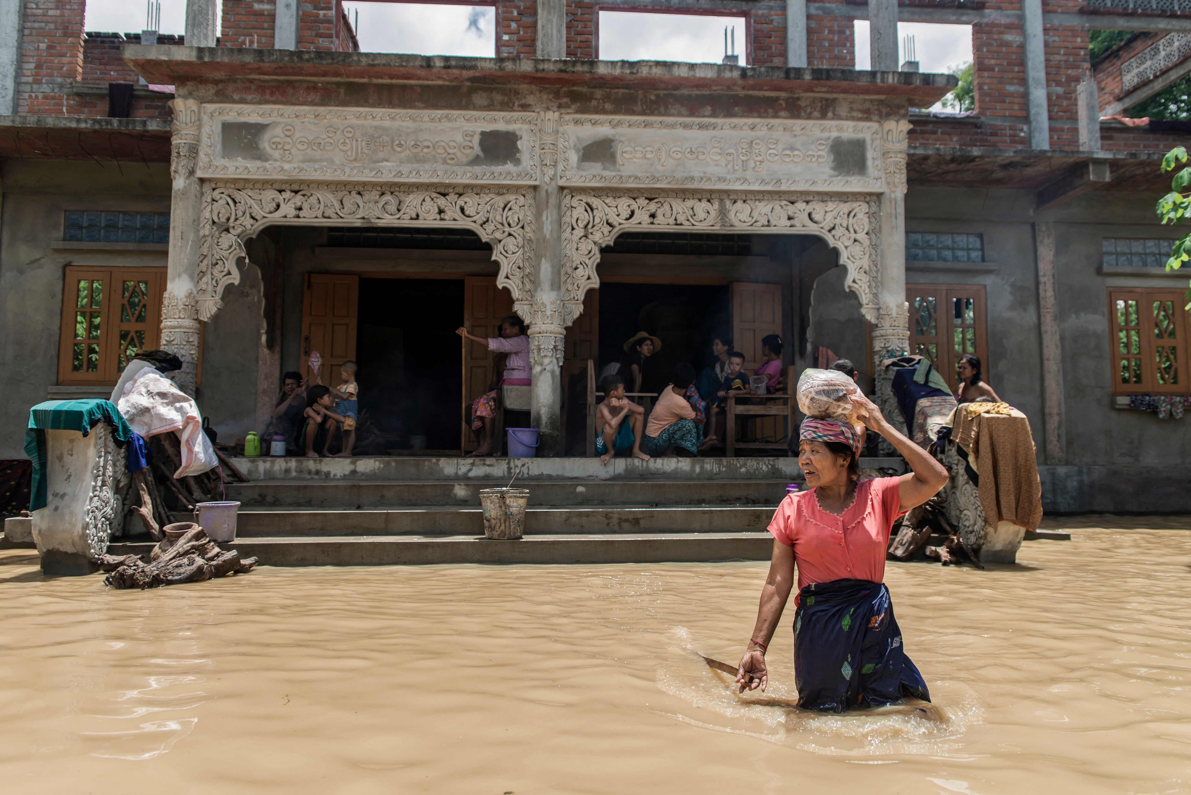 A woman wades through a flooded area due to monsoon rains and rising river water levels in Wetlet, Myanmar’s Sagaing region, on Monday. Photo: AFP