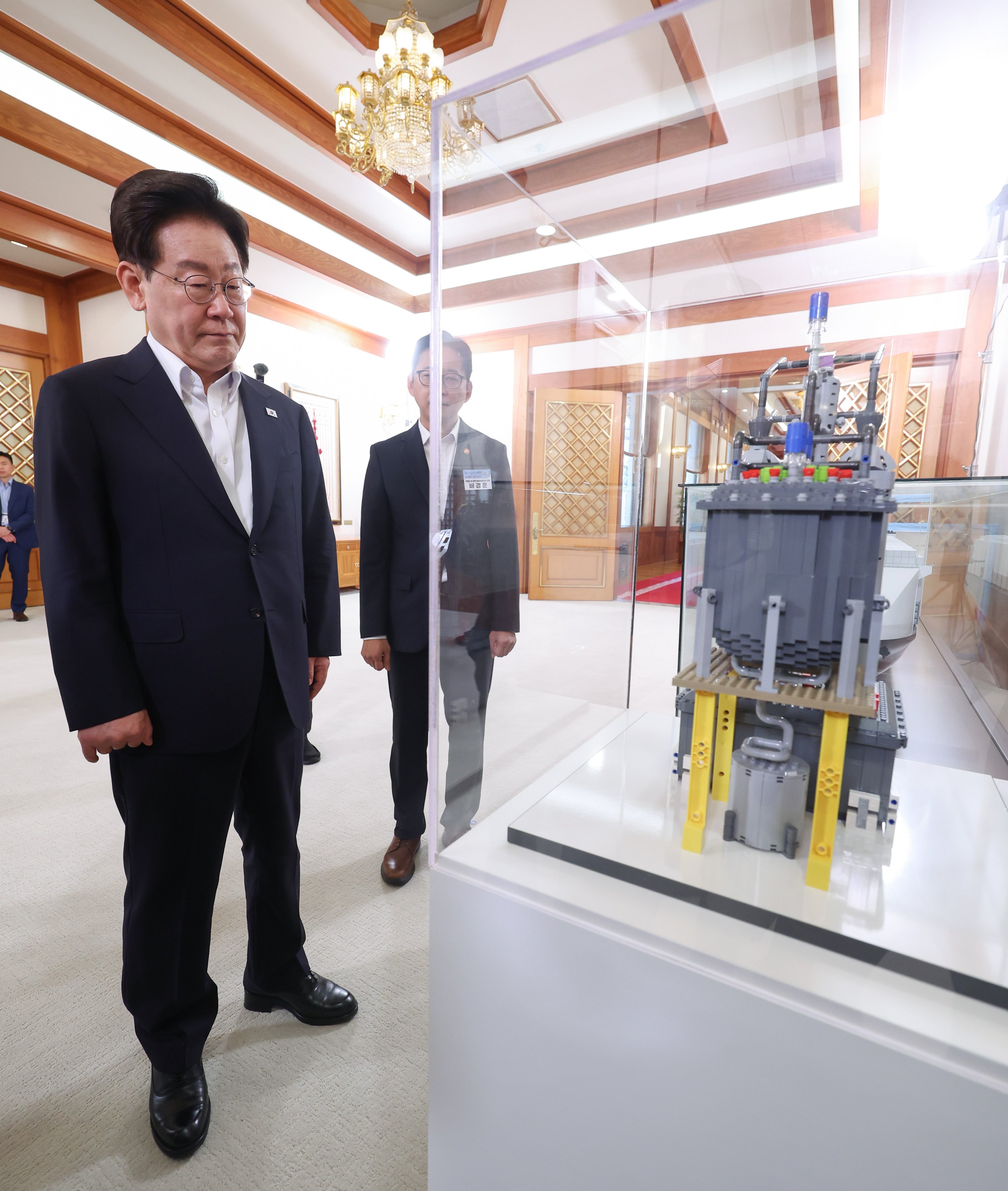 South Korean President Lee Jae Myung views a container vessel model equipped with a small modular reactor at the presidential office Cheong Wa Dae in Seoul on Wednesday. Photo: EPA/Yonhap