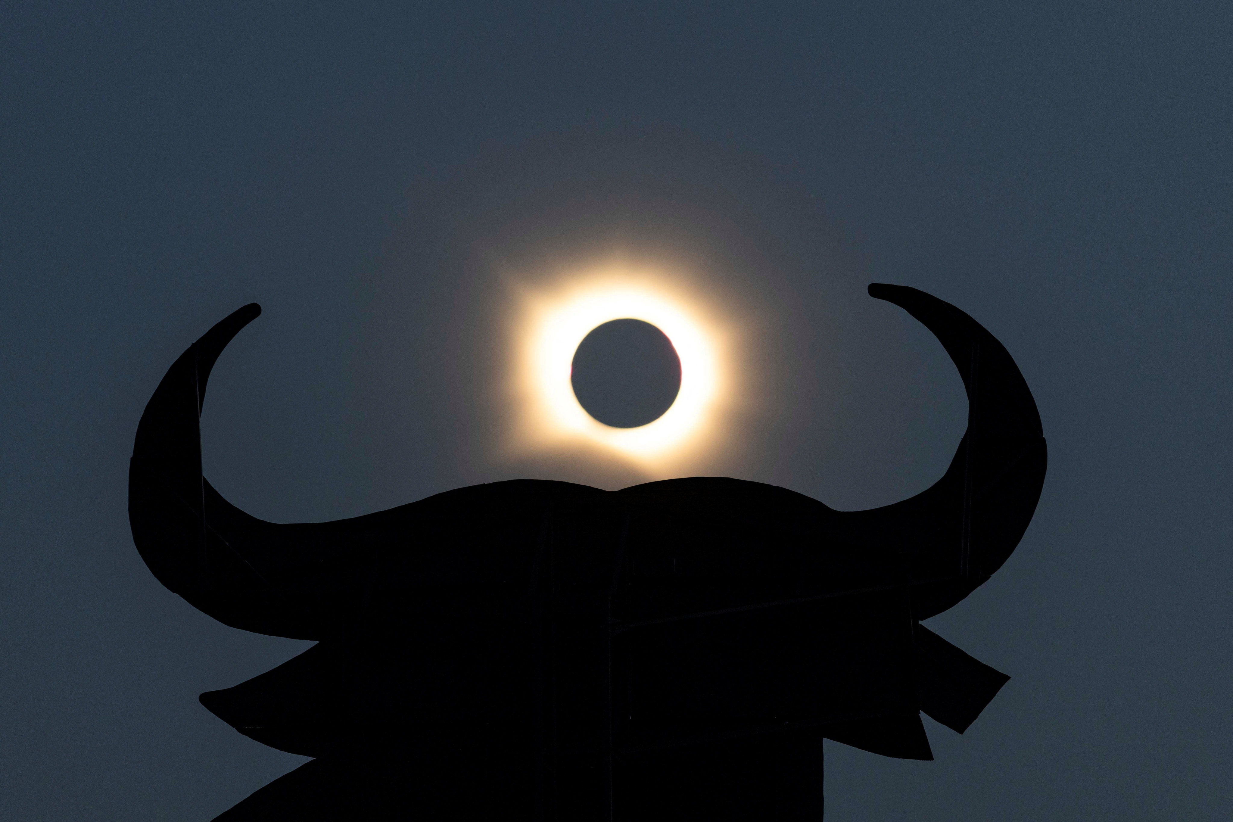 The moon completely covers the sun during a solar eclipse near the silhouette of an Osborne Bull, in Navarrete, northern Spain, on Wednesday. Photo: Reuters