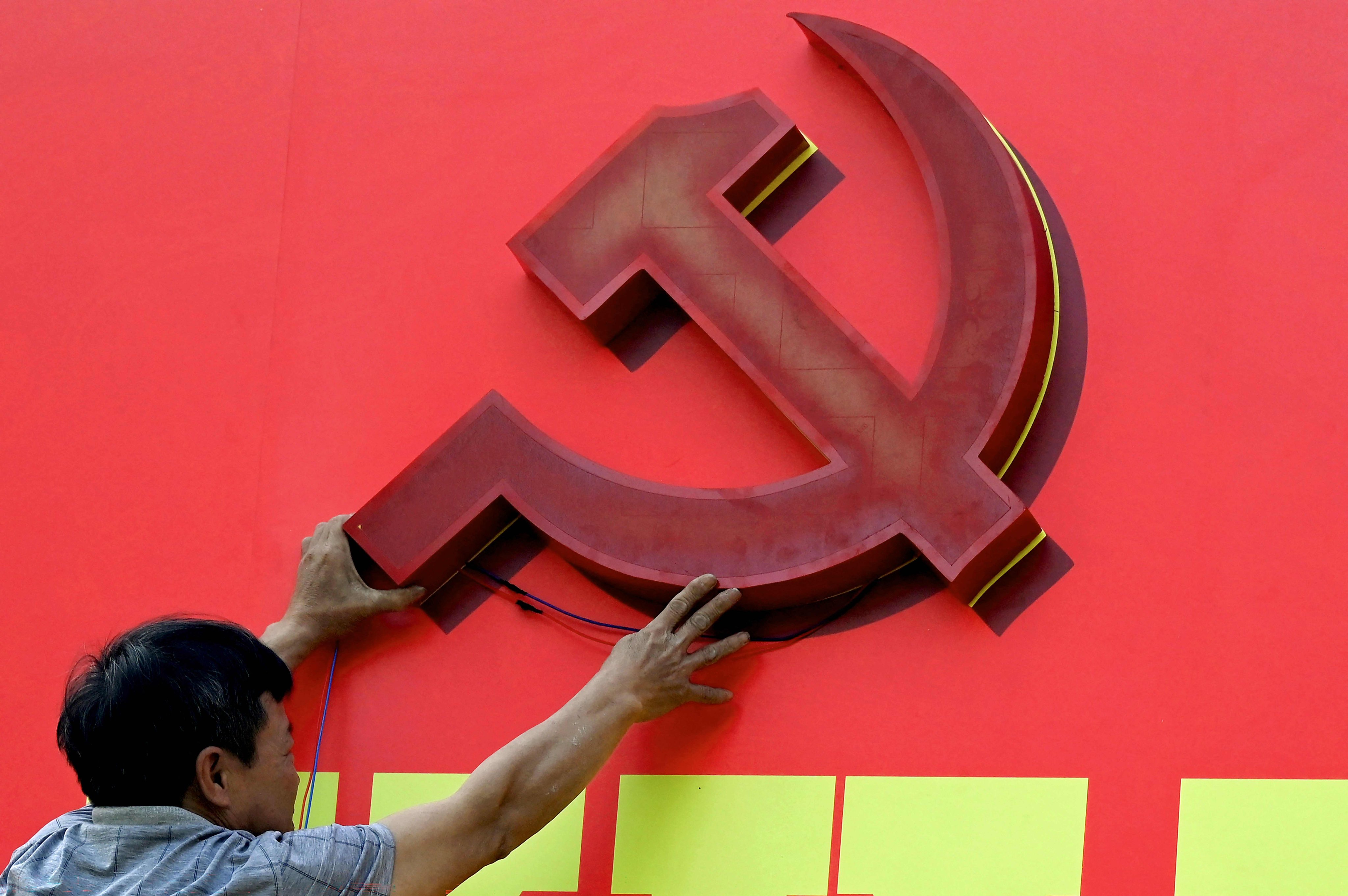 A worker installs a billboard advertising the 14th Congress of the Vietnamese Communist Party in Hanoi in January. Photo: AFP