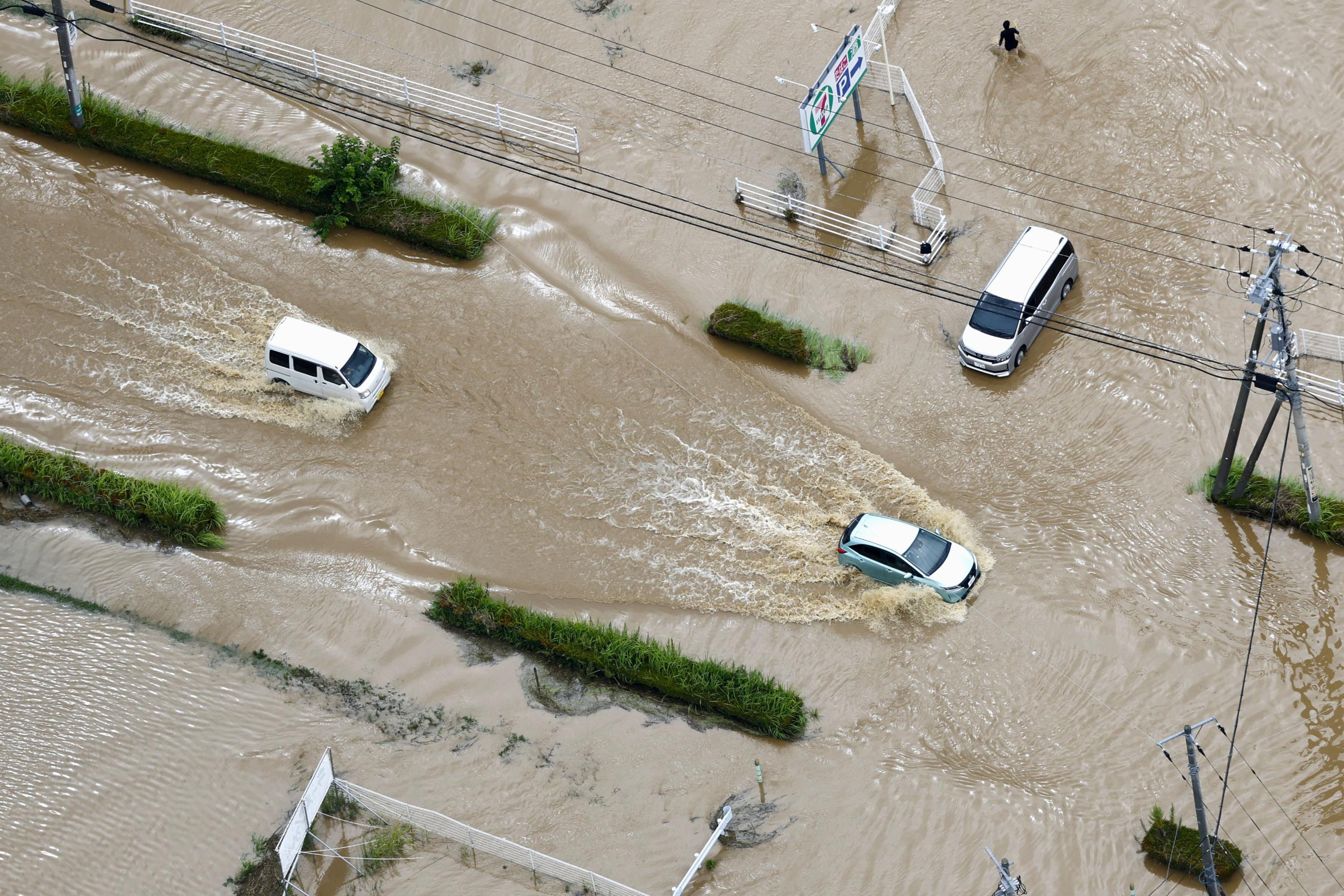Cars make their way through flooded roads after heavy rains in Chiba prefecture, Japan, on Friday. Photo: AP