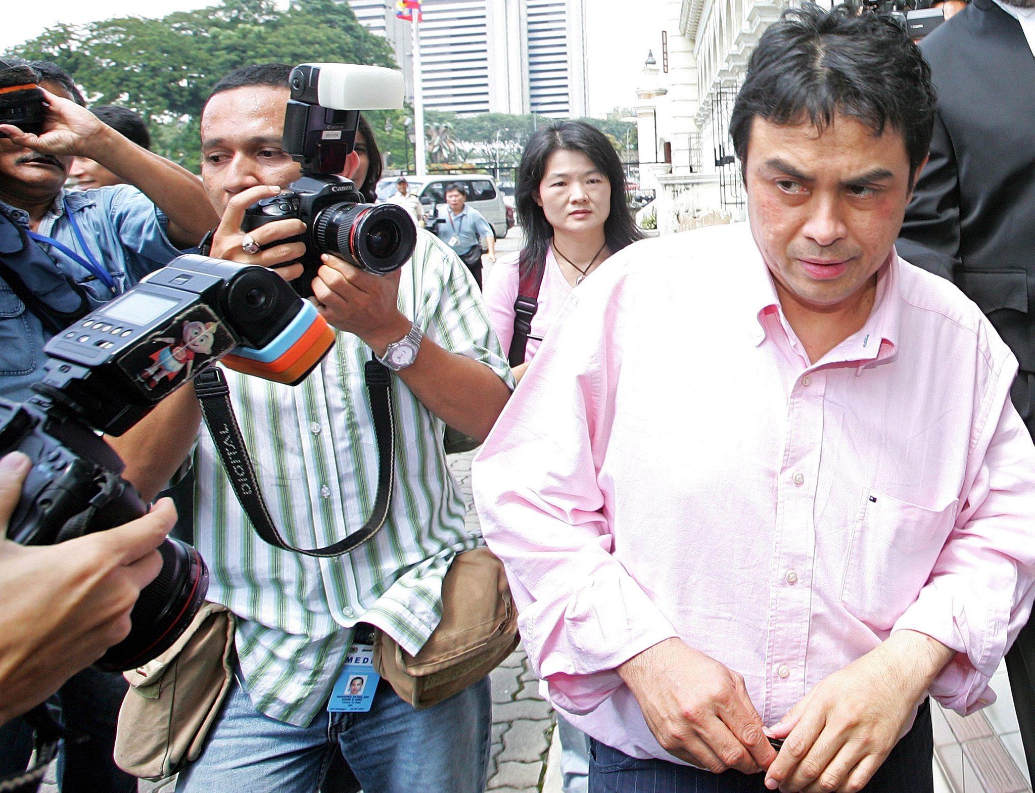 Malaysian political analyst Abdul Razak Baginda is chased by photographers as he leaves the High Court in Kuala Lumpur in 2006. Photo: EPA