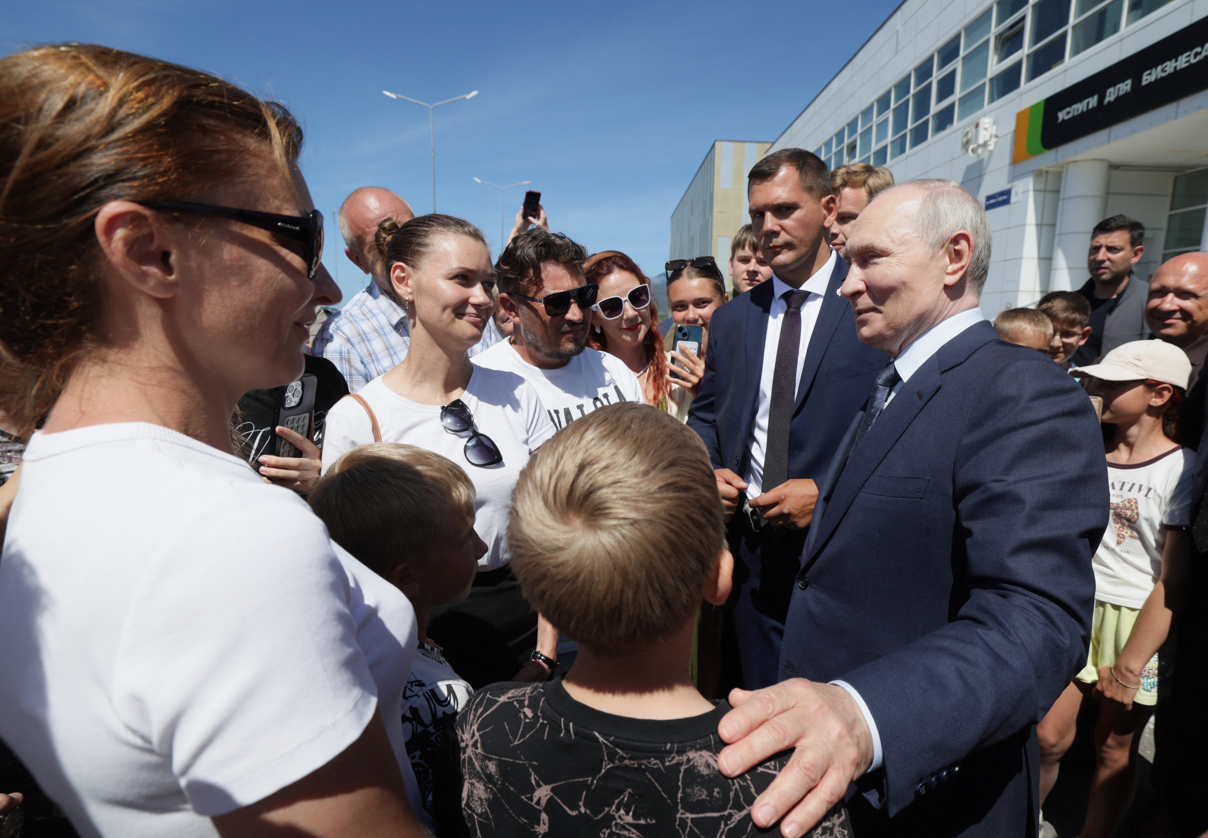 In this pool photograph distributed by the Russian state agency Sputnik, Russia’s President Vladimir Putin interacts with local residents on Iturup island, one of four islands in the contested chain known as the Kuril Islands in Russia and the Northern Territories in Japan, on August 13, 2026. (Photo by Gavriil Grigorov / POOL / AFP)