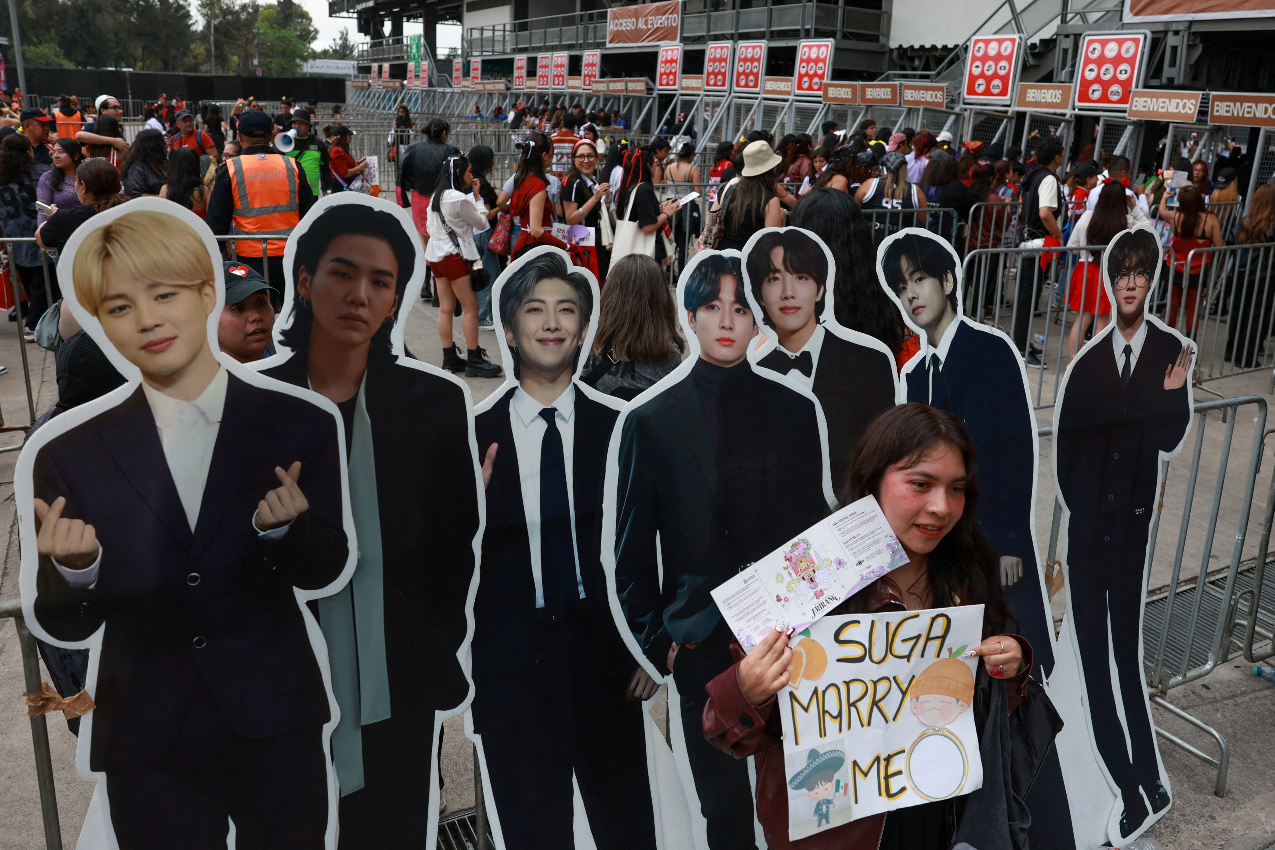 A fan poses with cardboard cut-outs of BTS stars outside a concert venue in Mexico City, Mexico, on May 7. Photo: Reuters