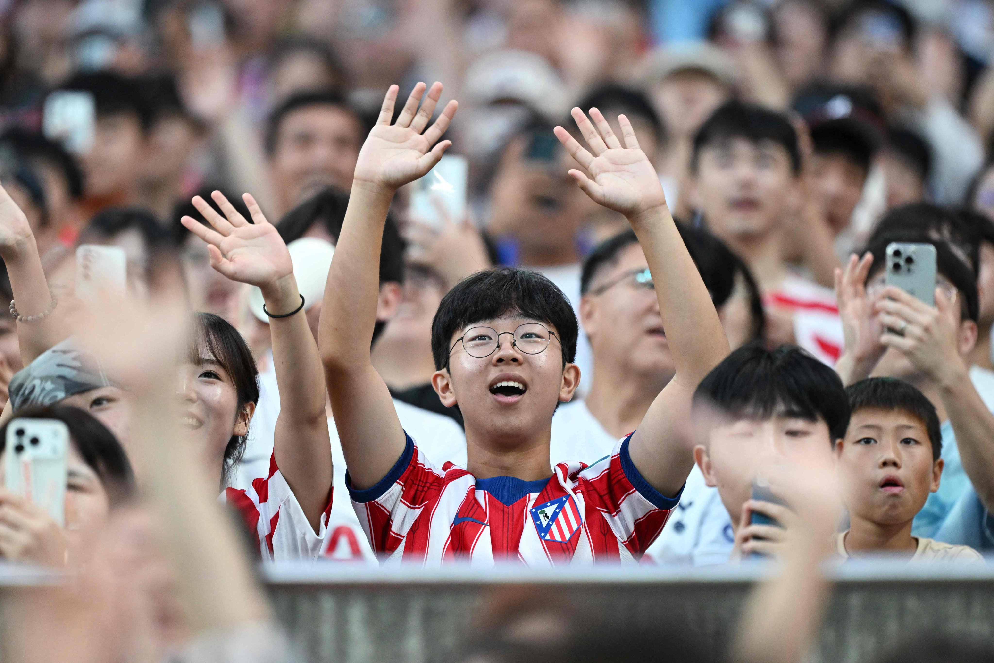 A fan wearing an Atletico Madrid top waves during an exhibition football match between the Spanish team and  Manchester City in Seoul. Photo: AFP