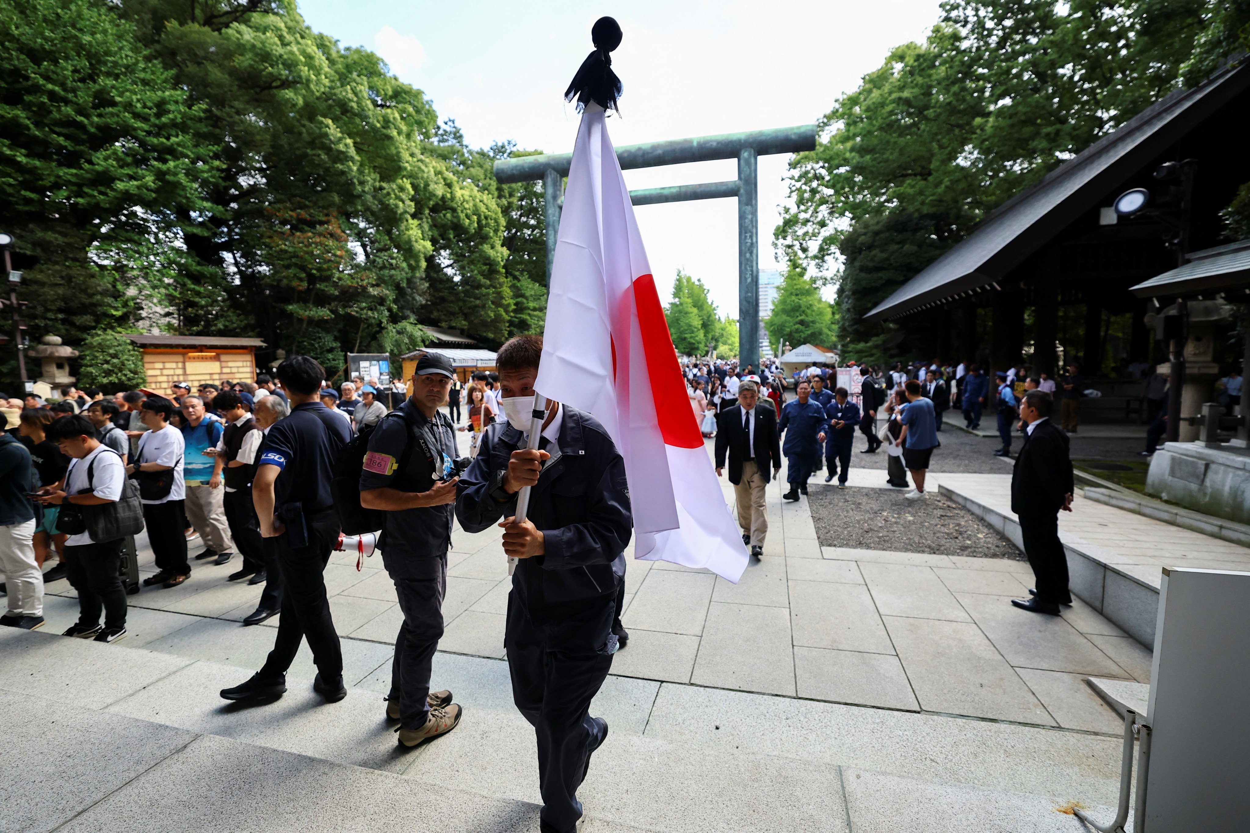 A person carries a Japanese flag as people visit to pay tribute to the war dead at Yasukuni Shrine in Tokyo on Saturday on the 81st anniversary of Japan’s surrender in World War II. Photo: Reuters