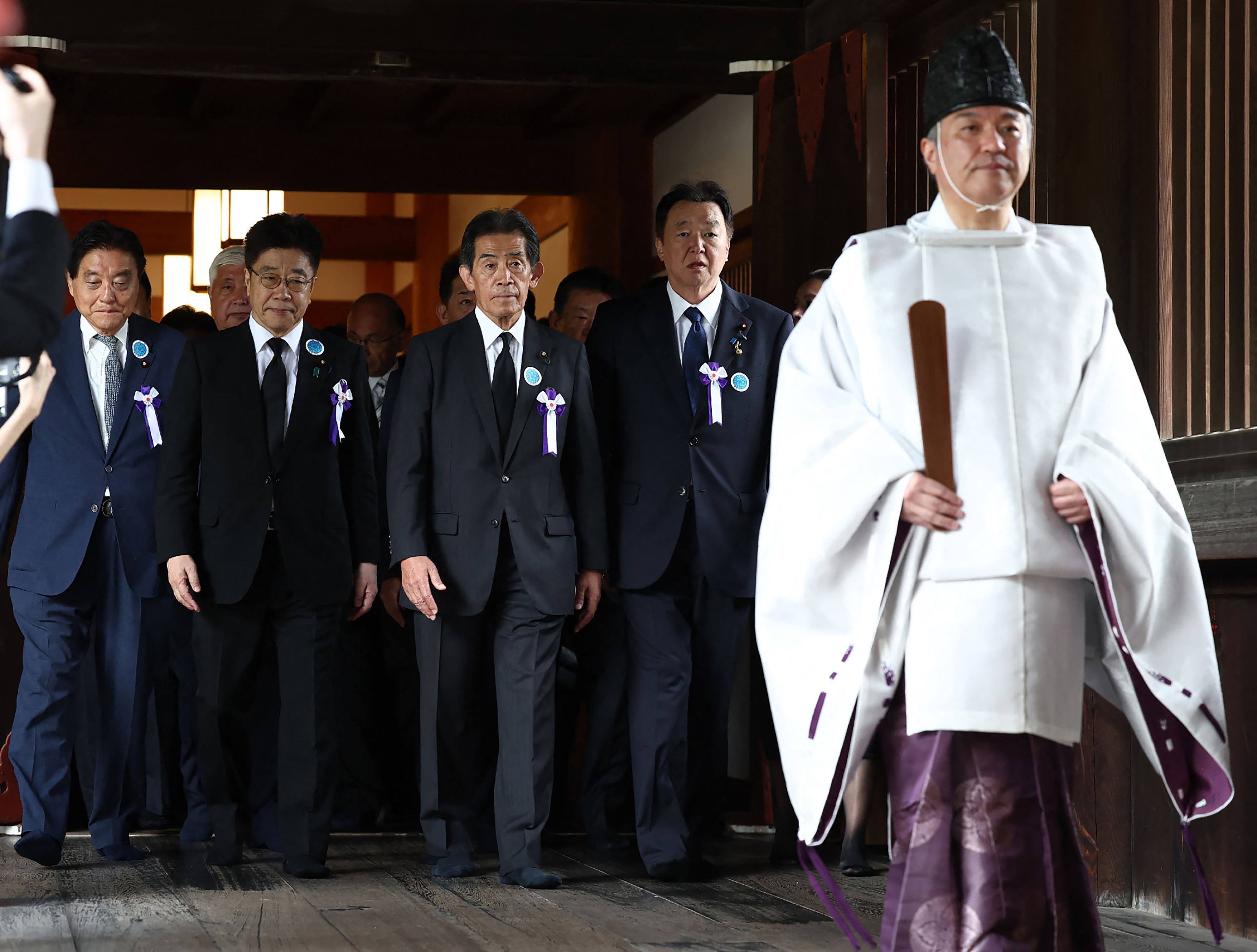 A group of Japanese lawmakers follows a Shinto priest during a visit to the Yasukuni Shrine in Tokyo on August 15. Photo: AFP