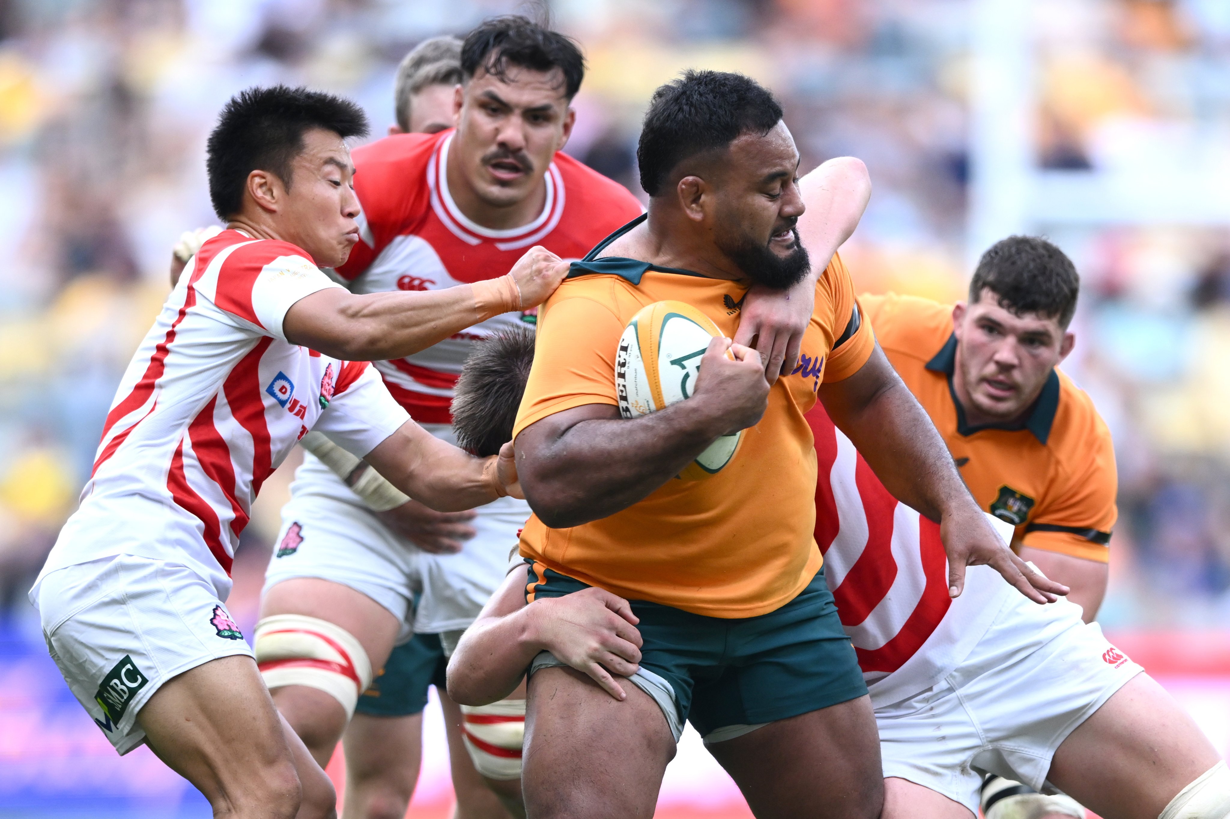 Taniela Tupou of Australia tries to fend off Japan’s players in the rugby Test match between the two sides in Townsville, Australia. Photo: EPA
