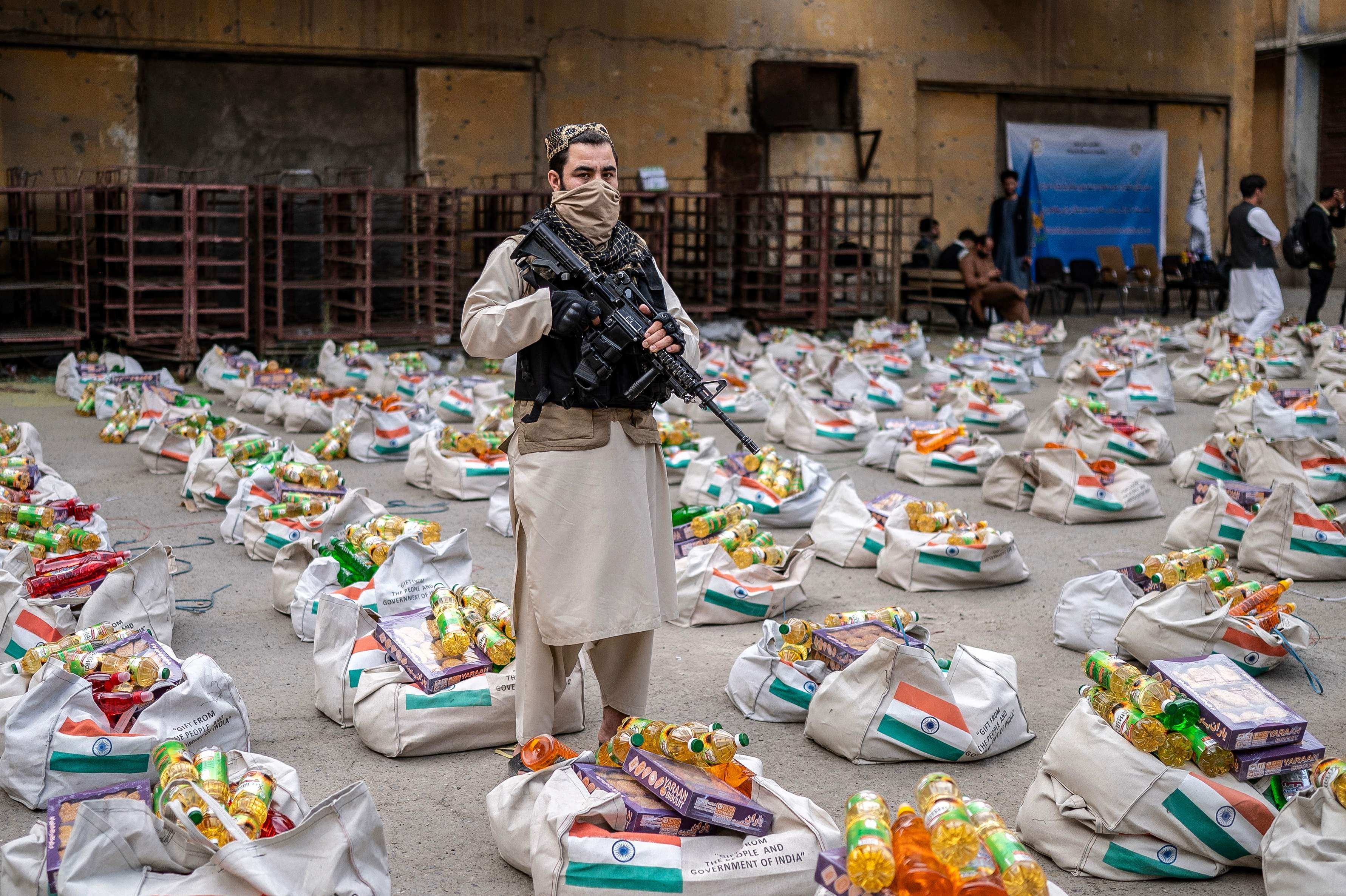 Taliban security personnel stans guard next to sacks of food aid donated by the Indian government in Kabul on May 18 last year. Photo: AFP