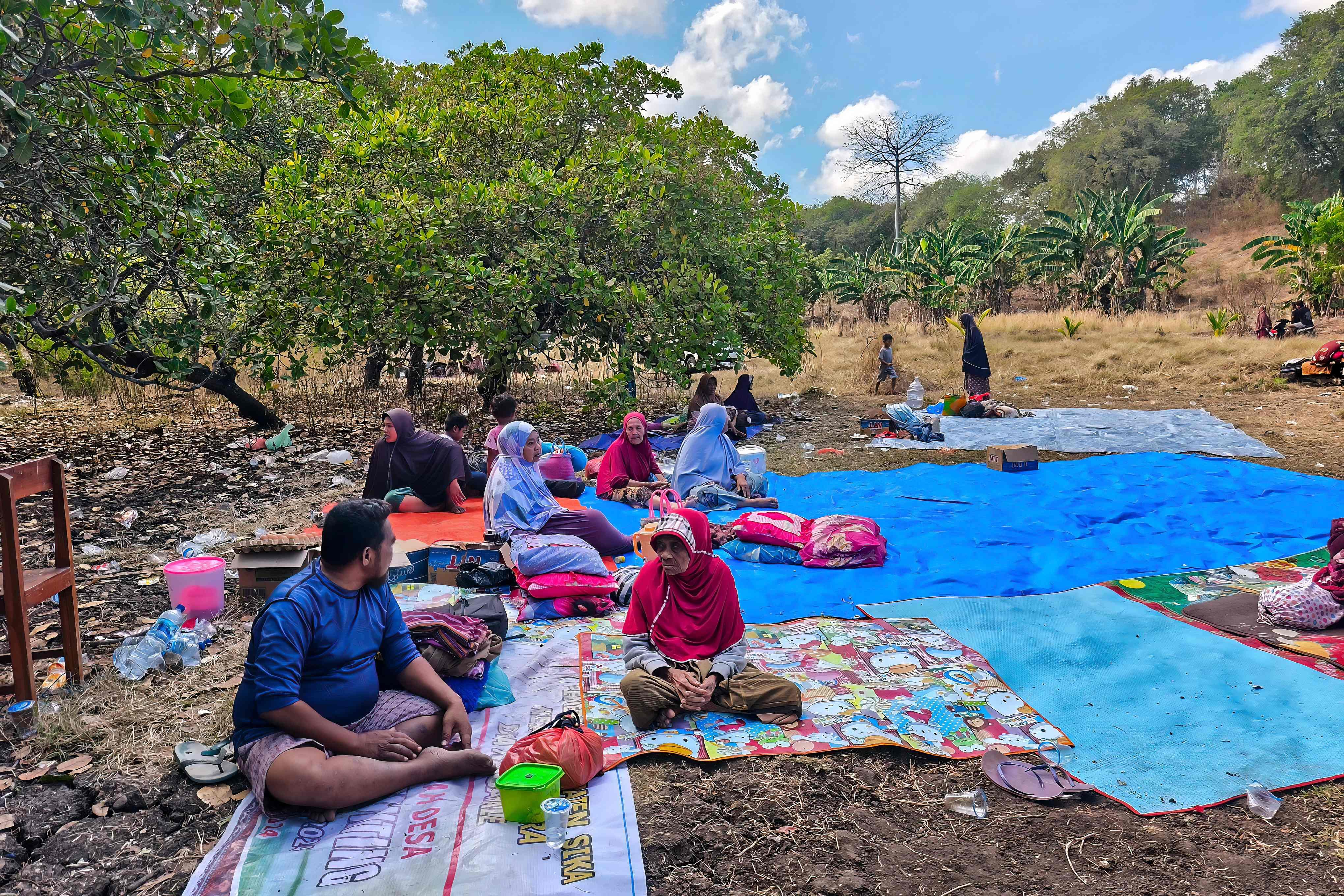 Villagers look on after spending the night in an open field in Nangahale village in Sikka, Indonesia’s East Nusa Tenggara, on Sunday. Photo: AFP