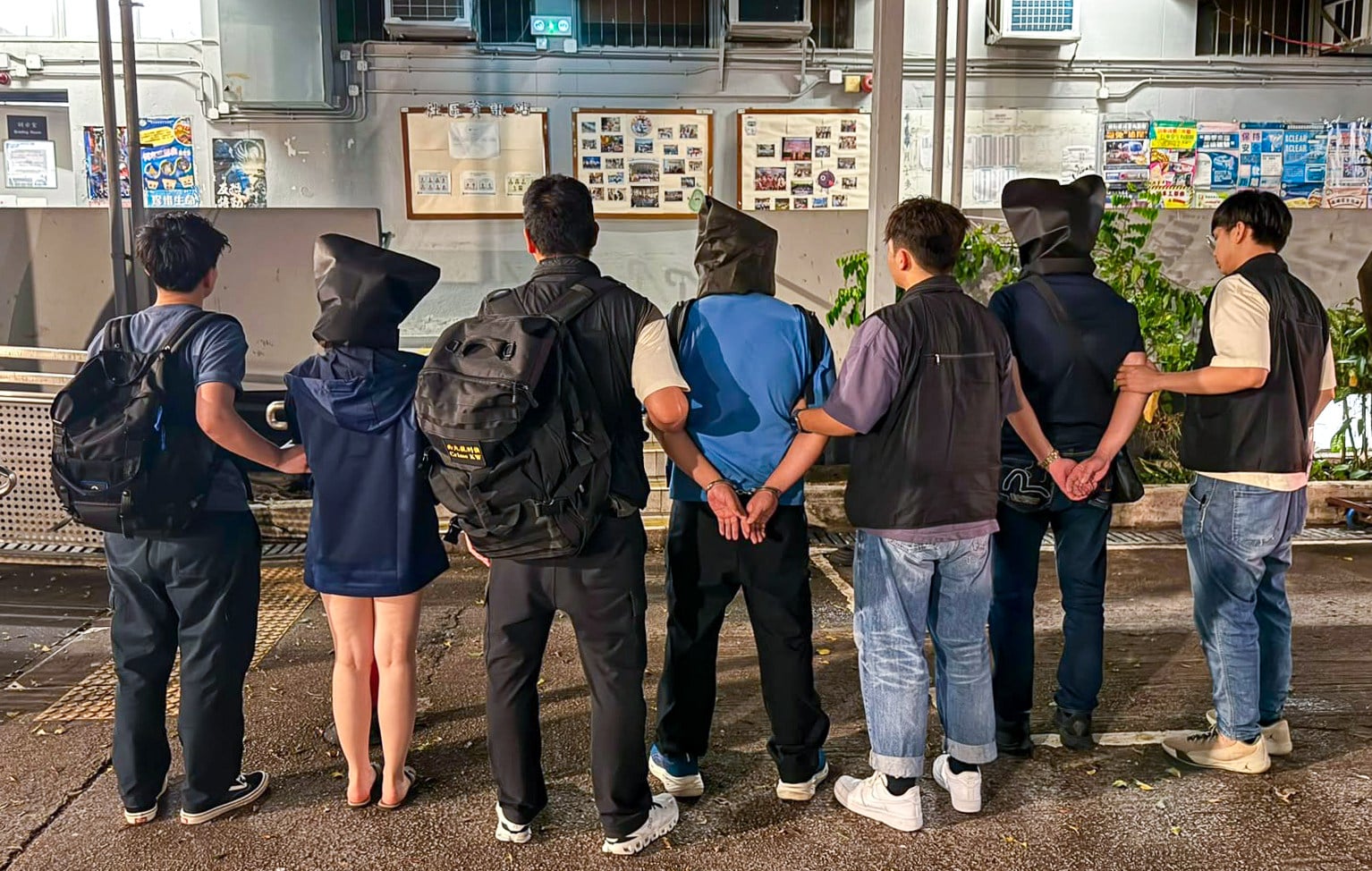 Police escort suspects arrested as part of a crackdown on a phone scam syndicate. Photo: Handout