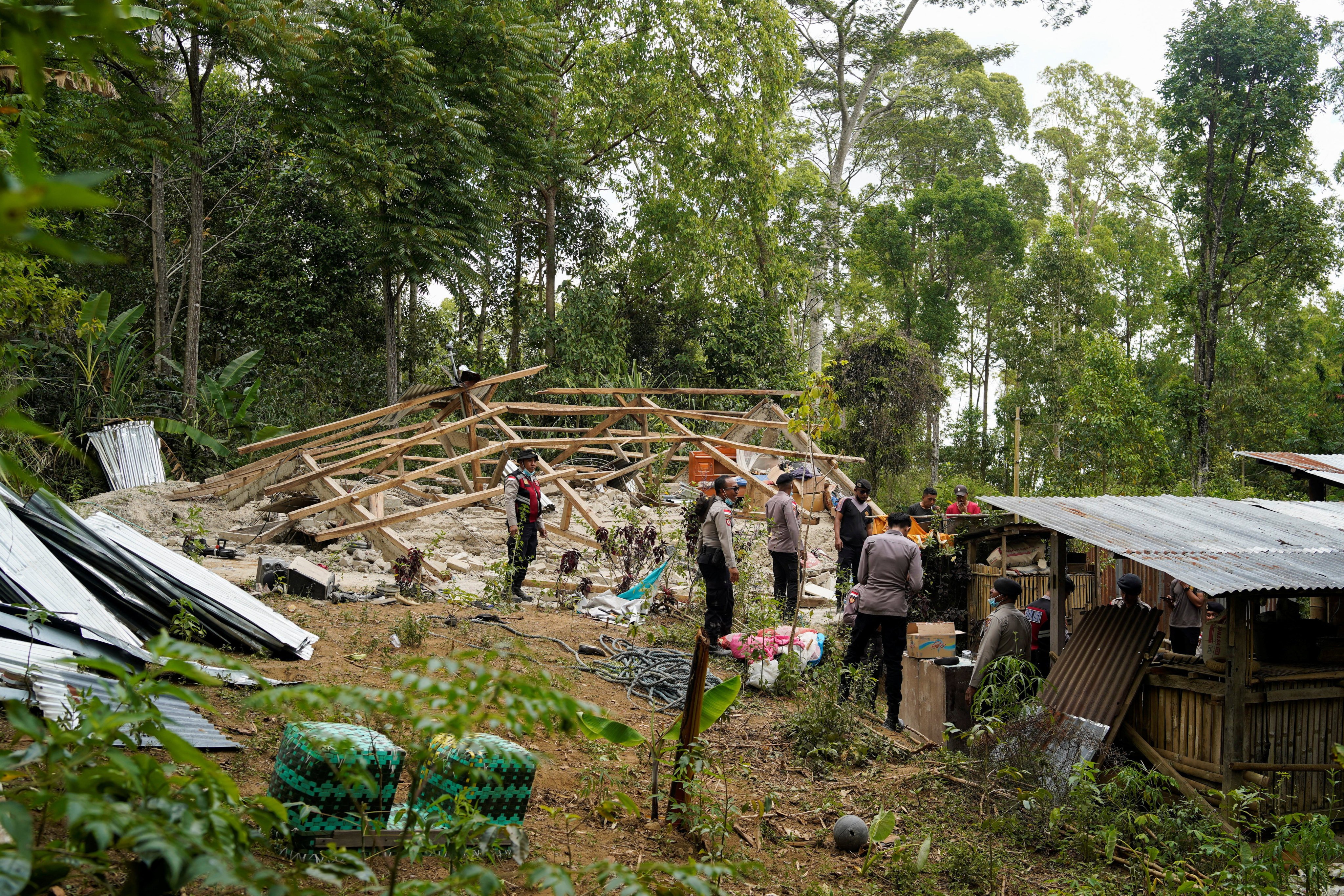 Police officers inspect a damaged house in Manggarai, Indonesia’s East Nusa Tenggara province, on Sunday. Photo: Reuters