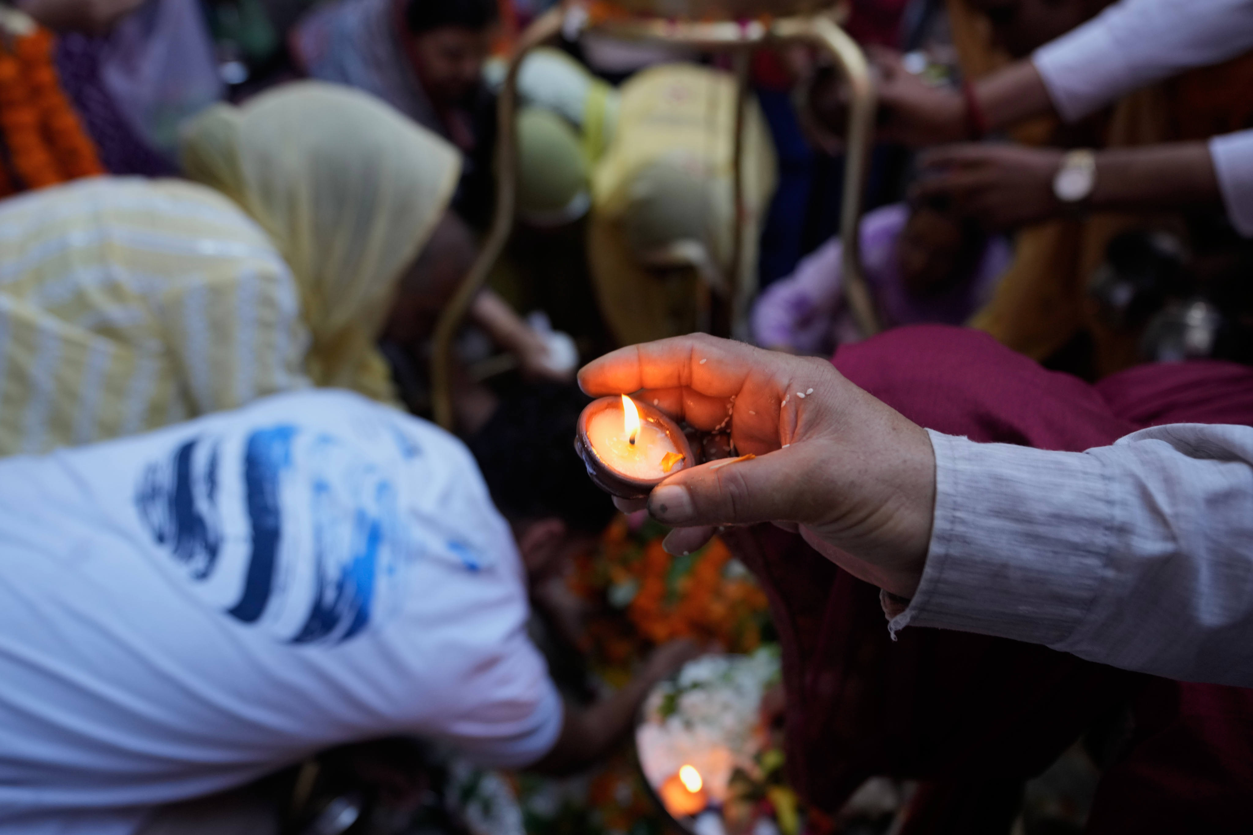 A Hindu devotee lights an earthen lamp during the holy month of Sawan at a  temple in Jammu, India, on August 10. Photo: AP