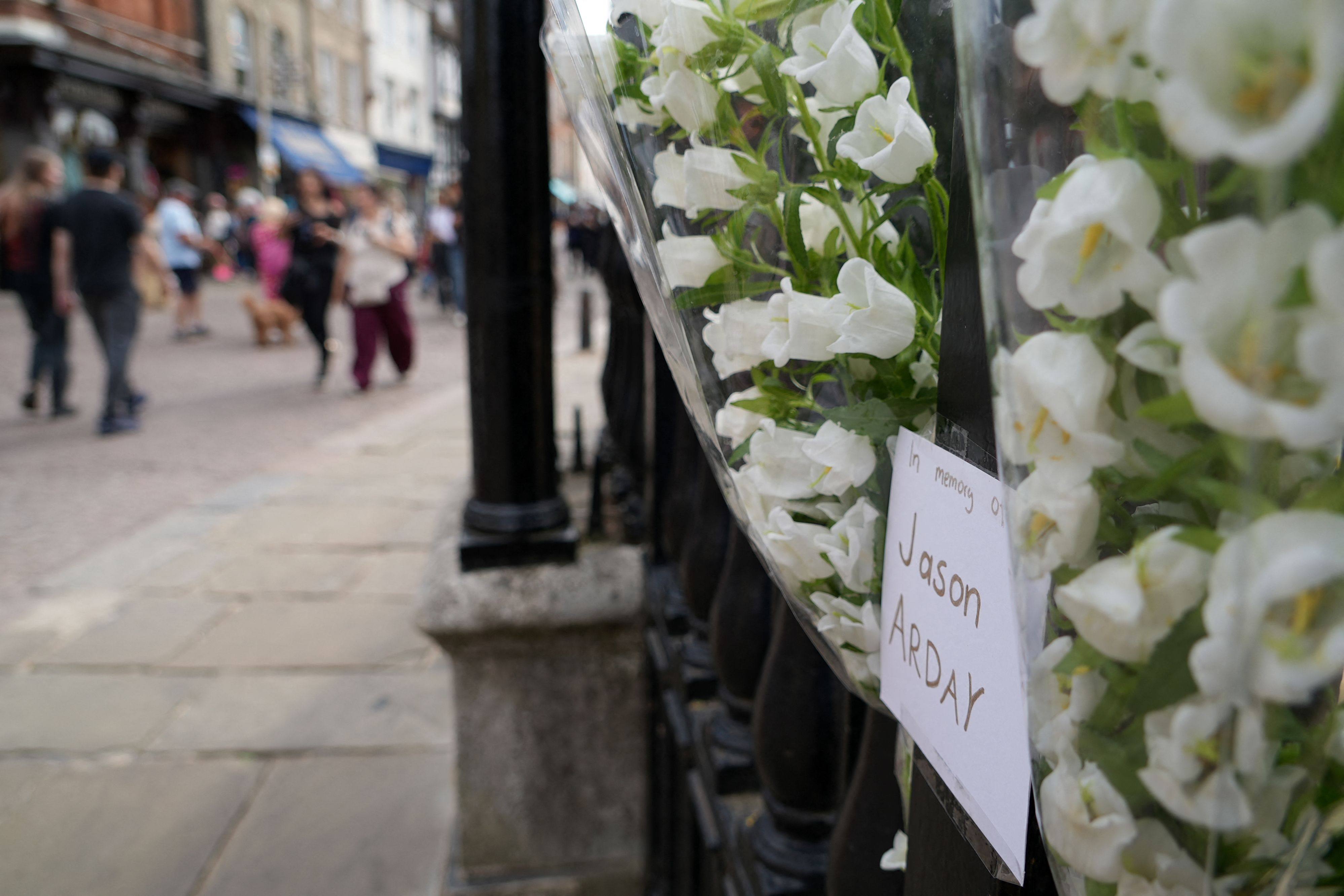Members of the public walk past floral tributes to remember academic Jason Arday, attached to the railings outside Senate House at the University of Cambridge on August 15. Cambridge’s vice-chancellor said on August 14 that the UK university was “desperately saddened” by the death of Arday, who quit the prestigious institution last week amid a plagiarism scandal. Photo: AFP